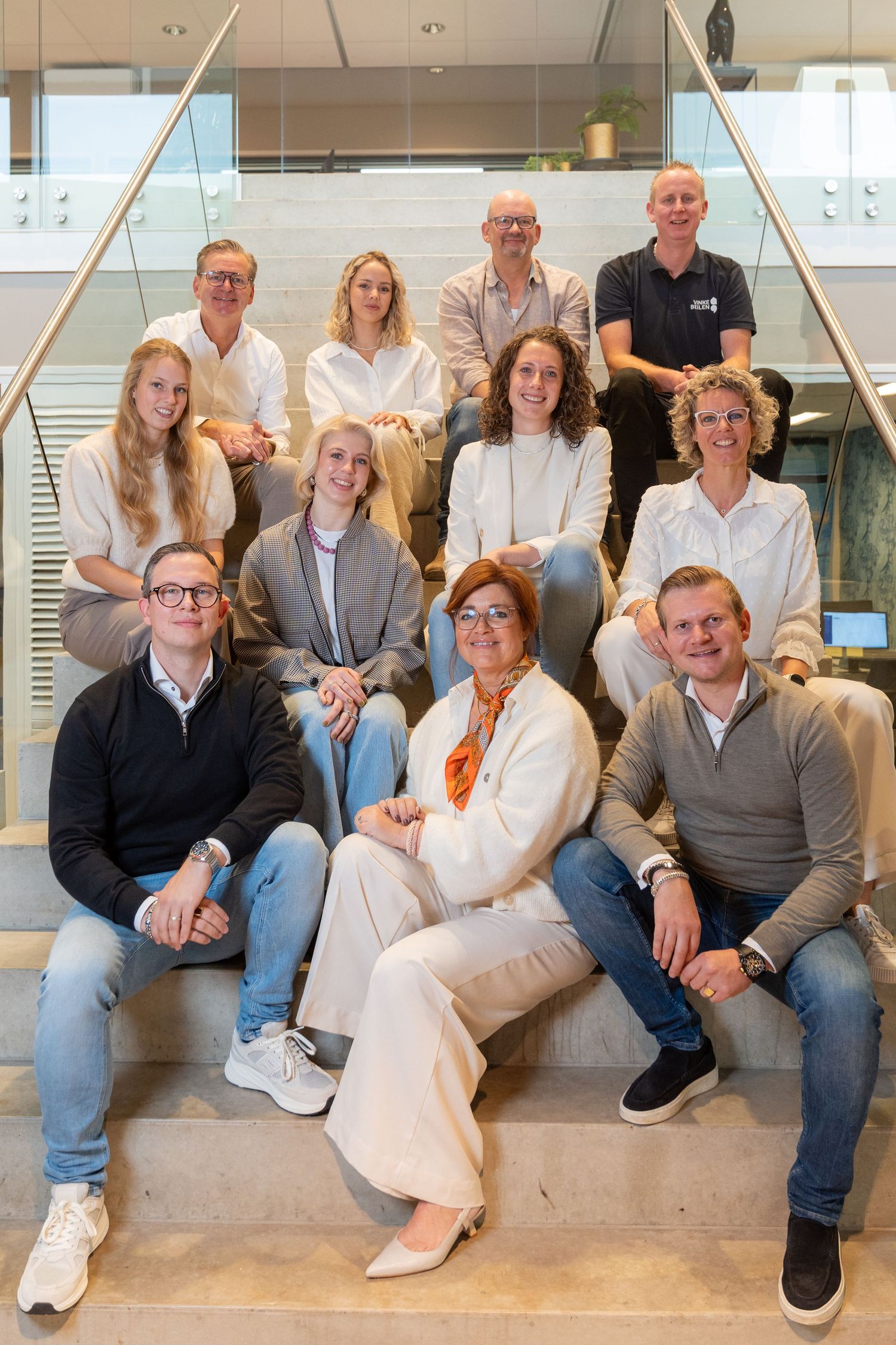 A group of people sitting together on a modern bench in a bright office setting.