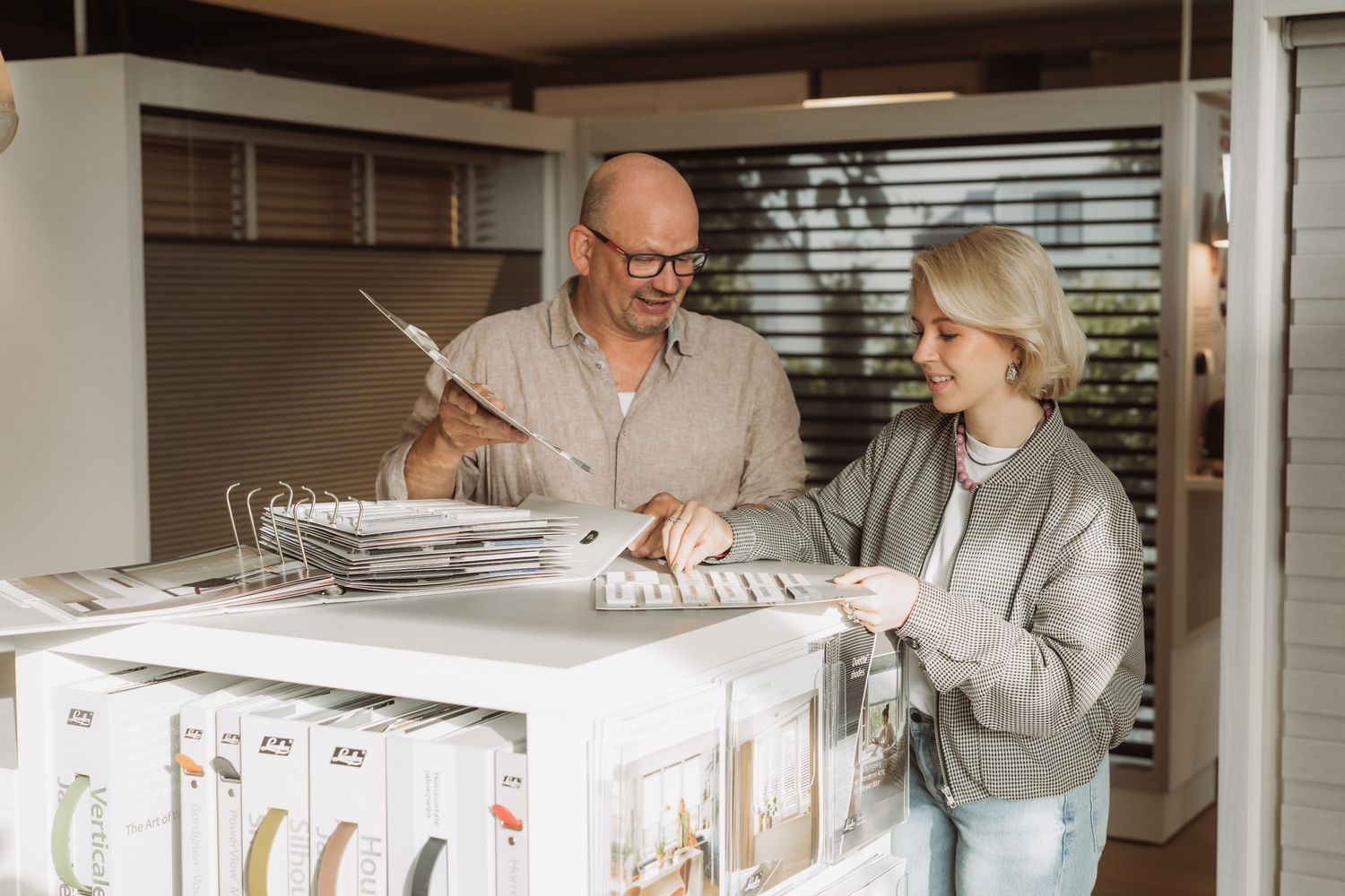 Healthcare professionals review medical records and documents at a desk in a clinical setting.