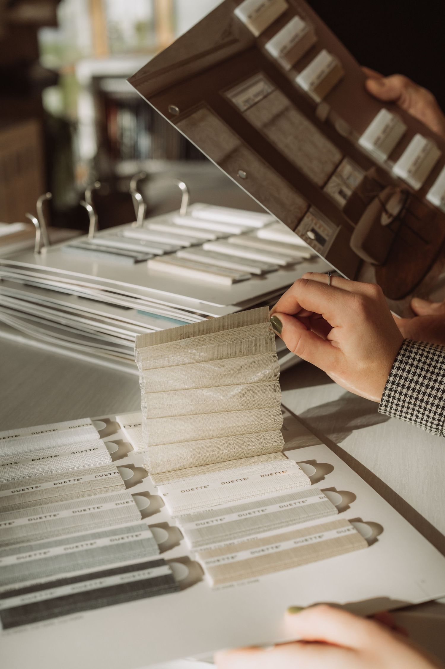 Hands sorting through stacks of paperwork and documents in a filing system under office lighting.