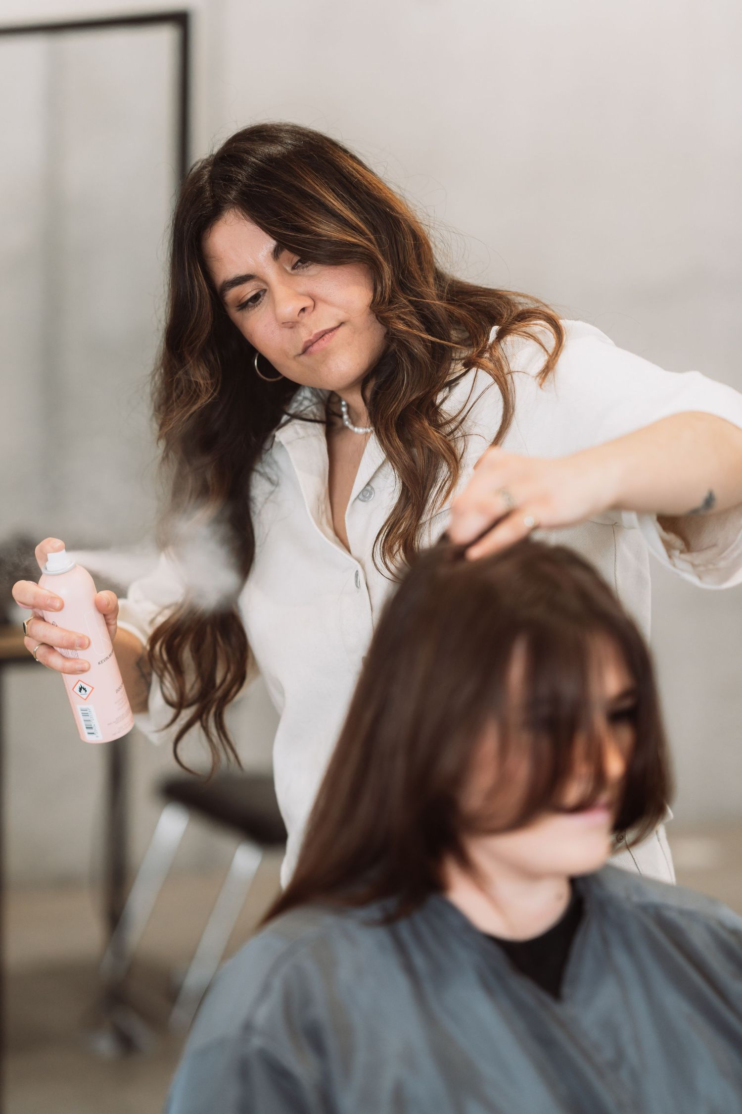 Hair styling professional applying product during a salon treatment.
