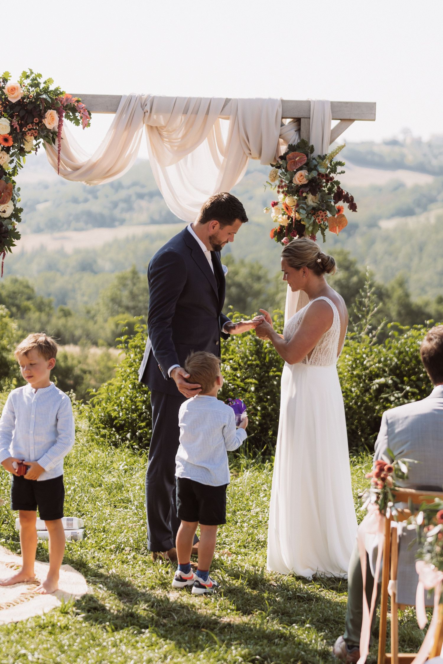 A series of outdoor wedding ceremony photos showing tender moments between family members in a scenic hilltop setting.
