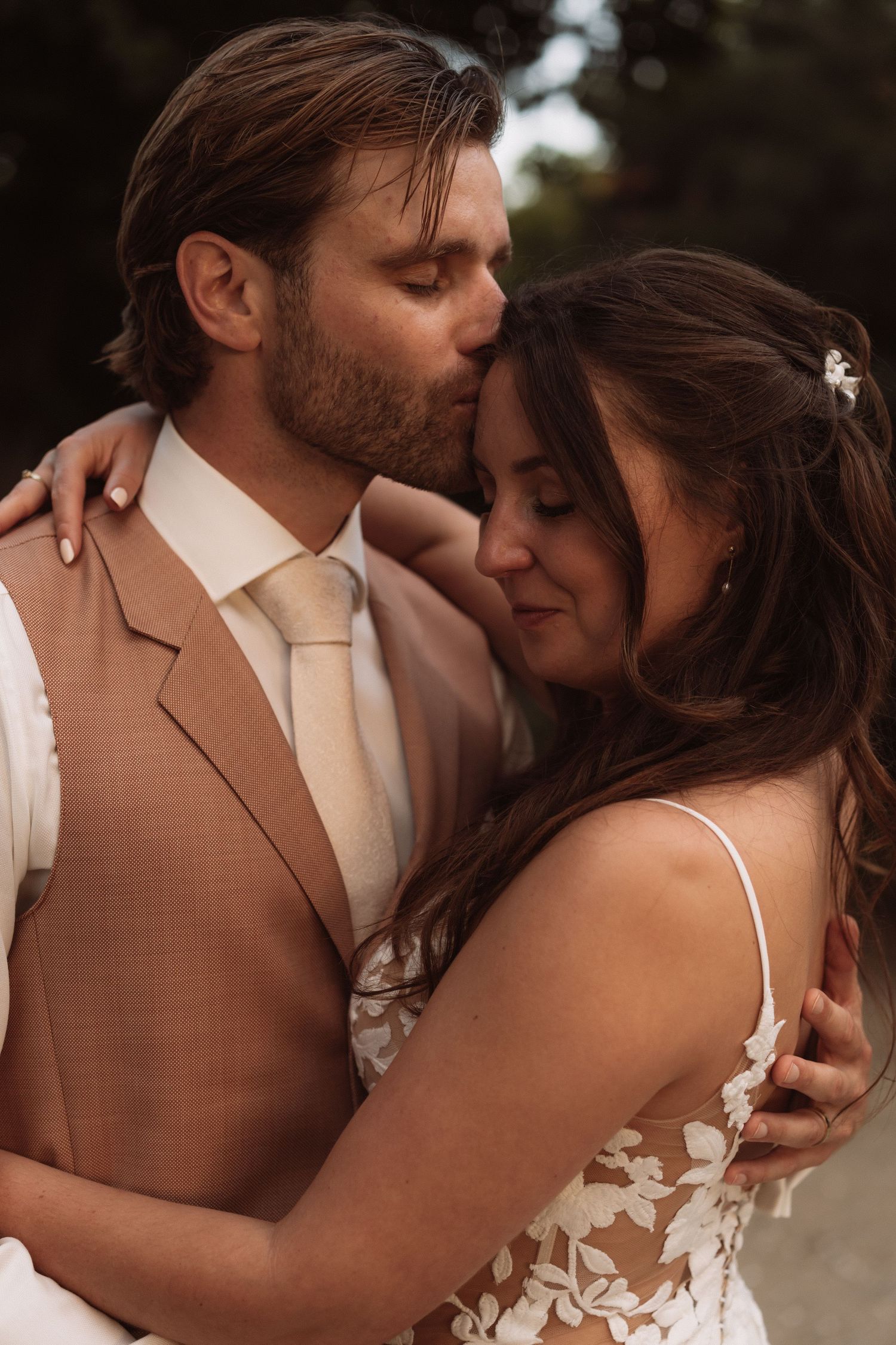 A romantic sequence of intimate moments between a couple in wedding attire, with the groom in a tan suit.