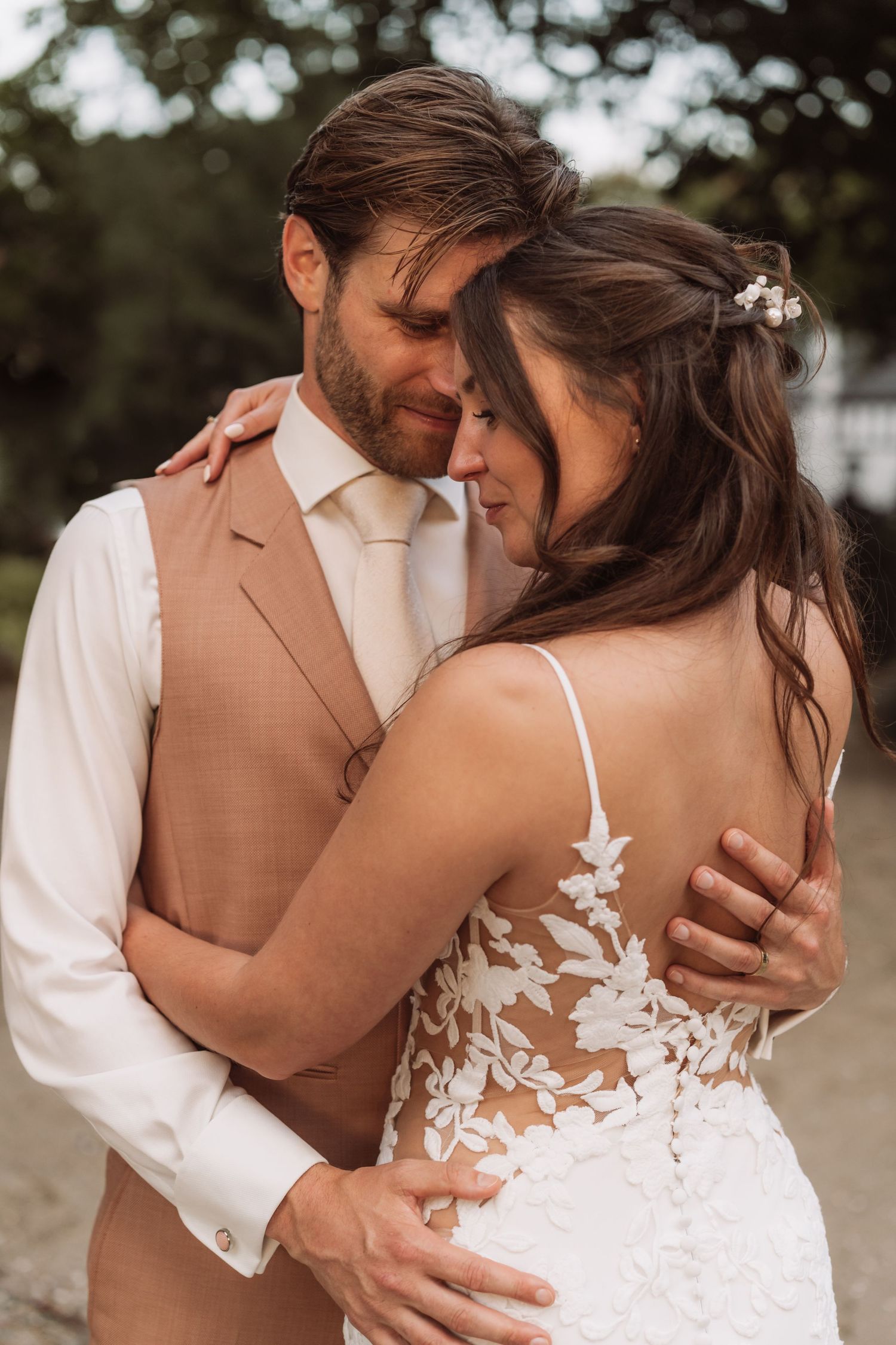 A romantic wedding couple embraces intimately in a series of tender outdoor portrait shots.