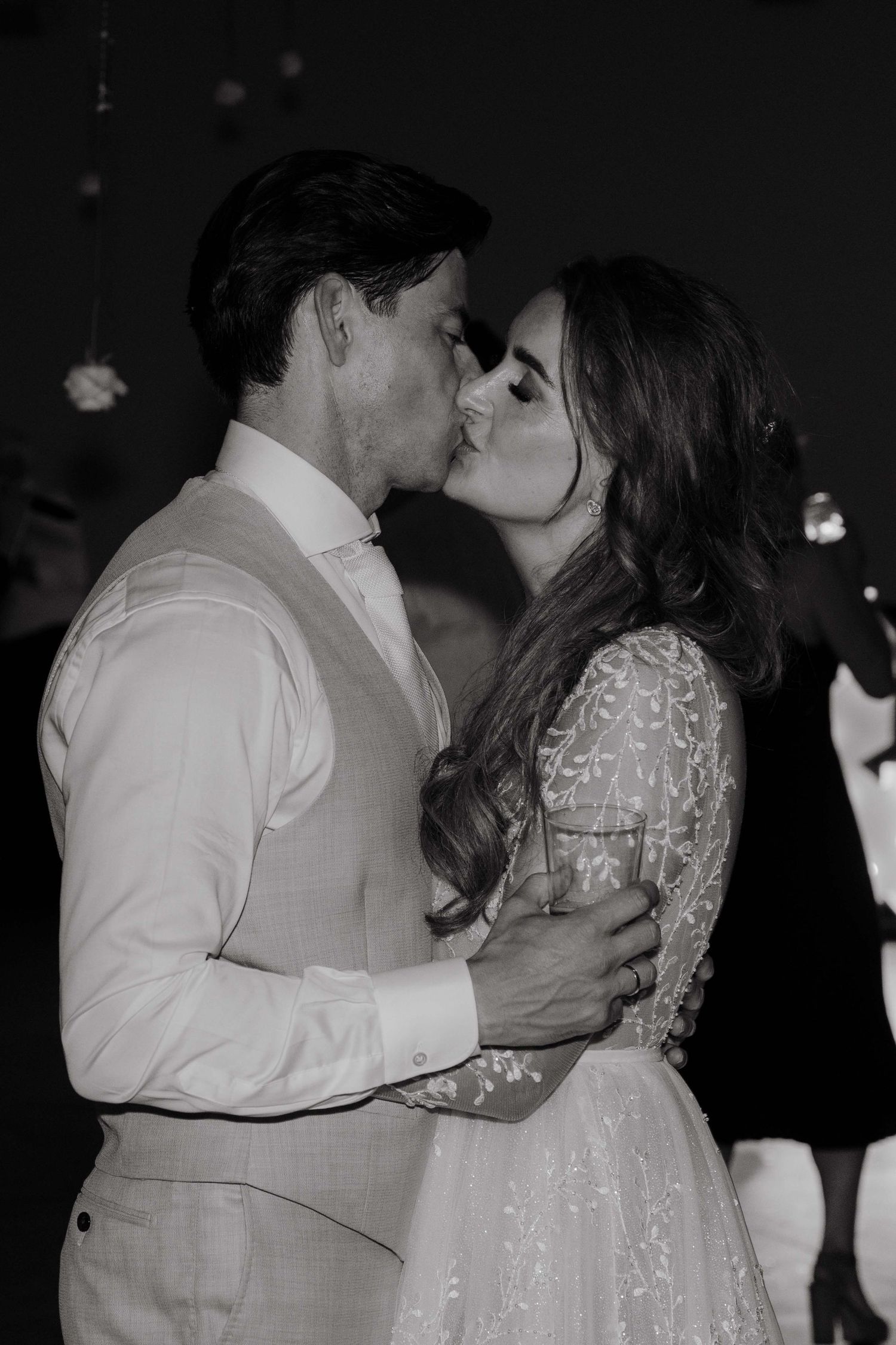 A romantic sequence of black and white photos showing a couple in wedding attire sharing a tender kiss on the dance floor.