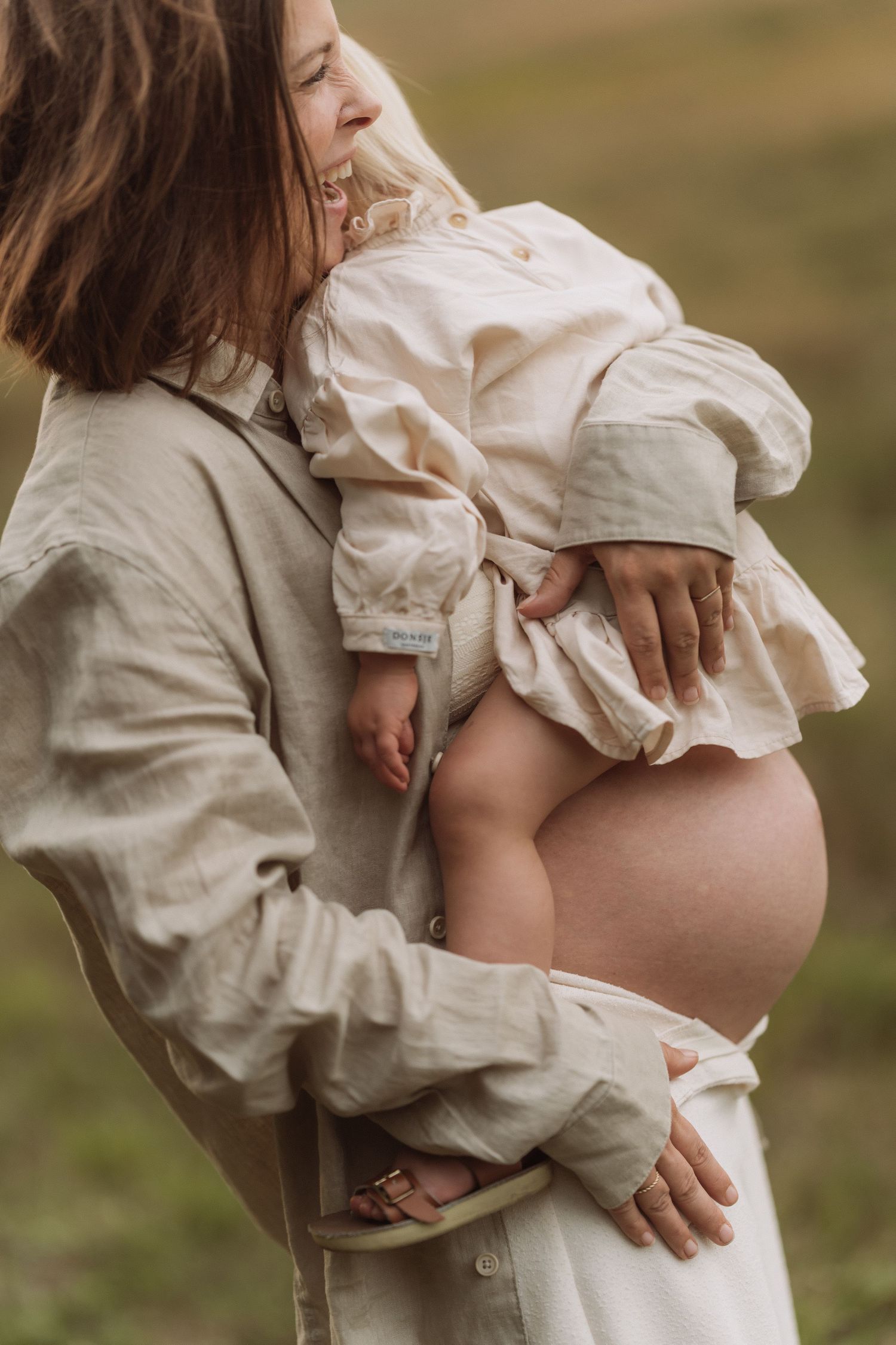 Close-up sequence showing a pregnant woman's belly being gently touched in soft natural light.