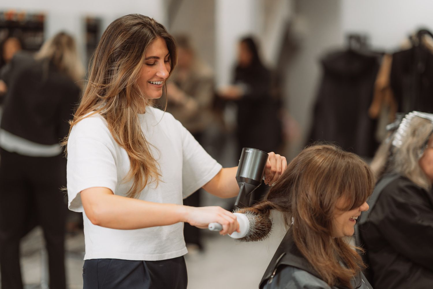 Hairstylist working on client's hair in a modern salon setting.