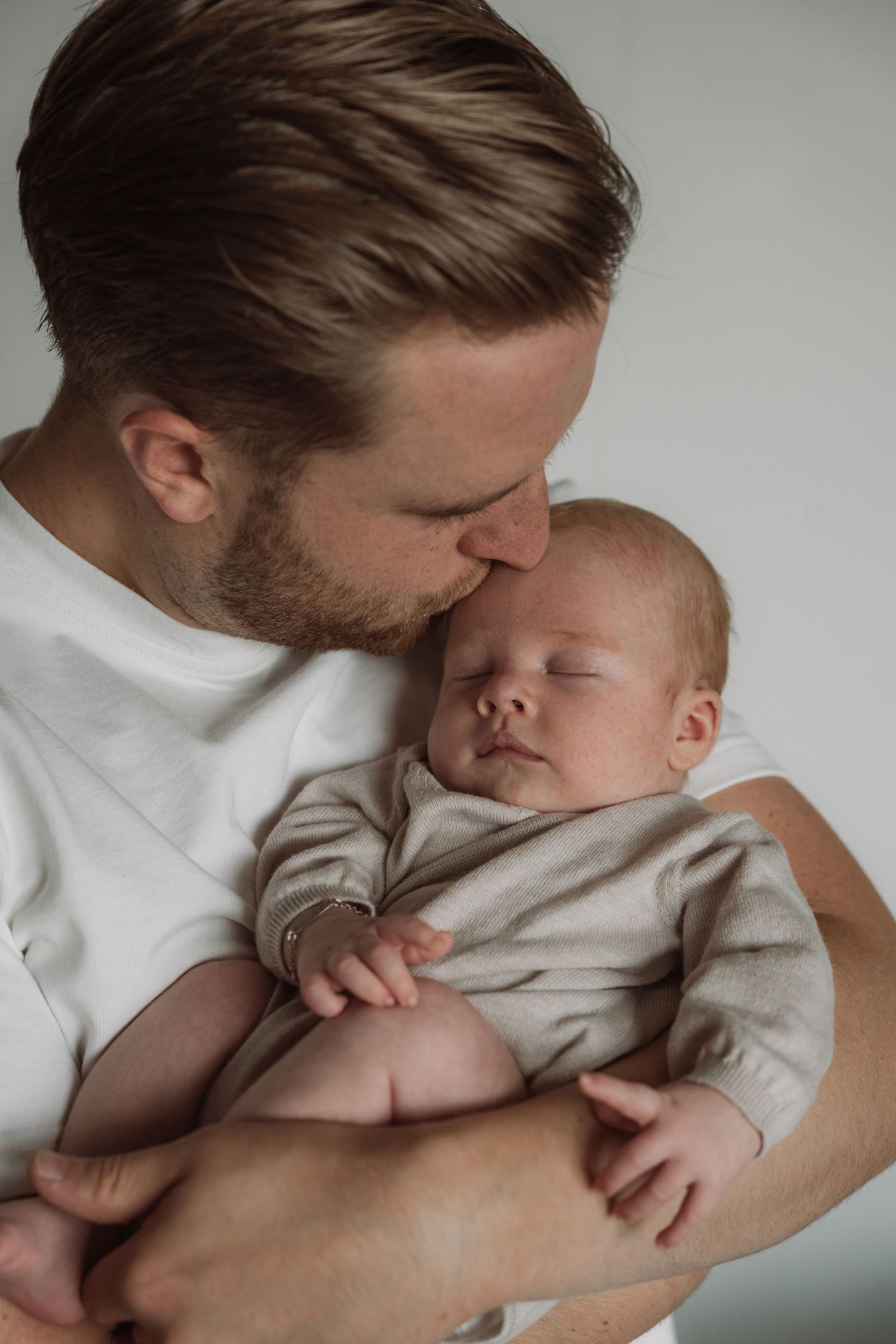 Tender moments between parent and baby captured in intimate black and white photography.