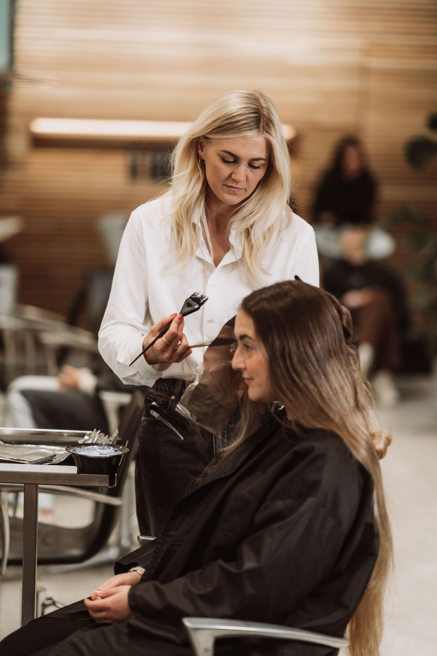 Hair styling session in progress at a modern salon with warm lighting.