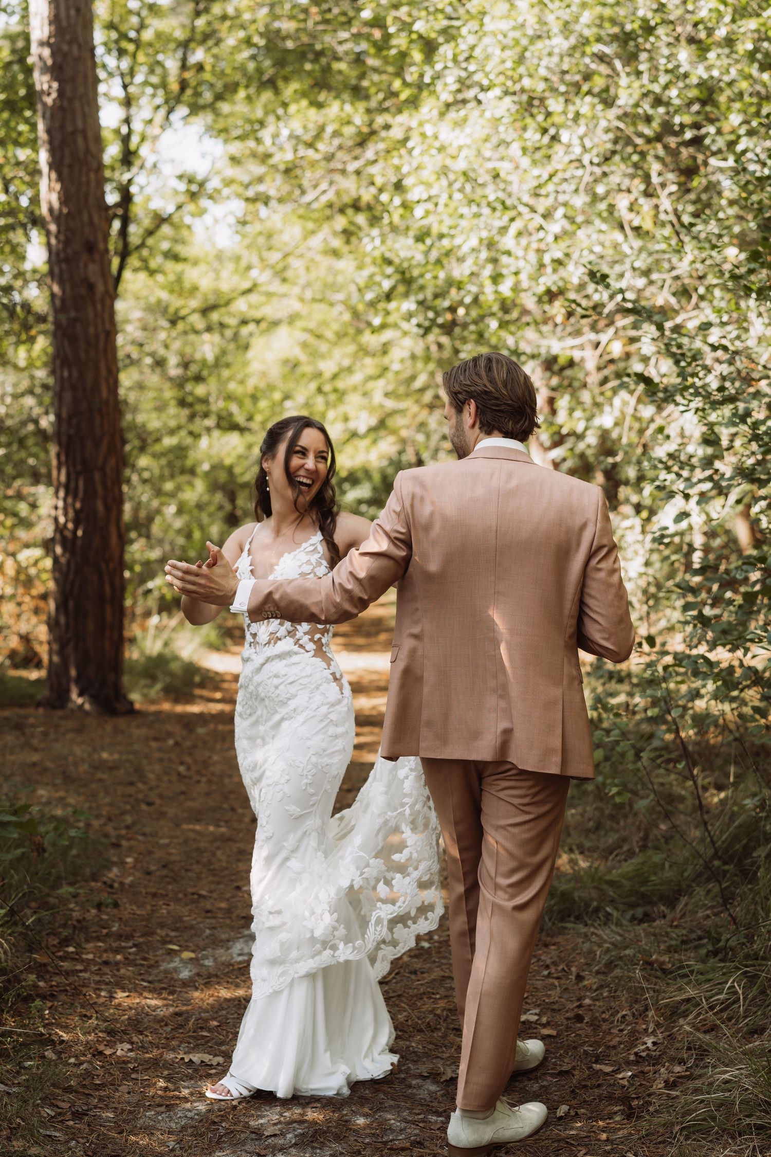 A wedding couple walks through a wooded forest path in a romantic sequence of candid moments.