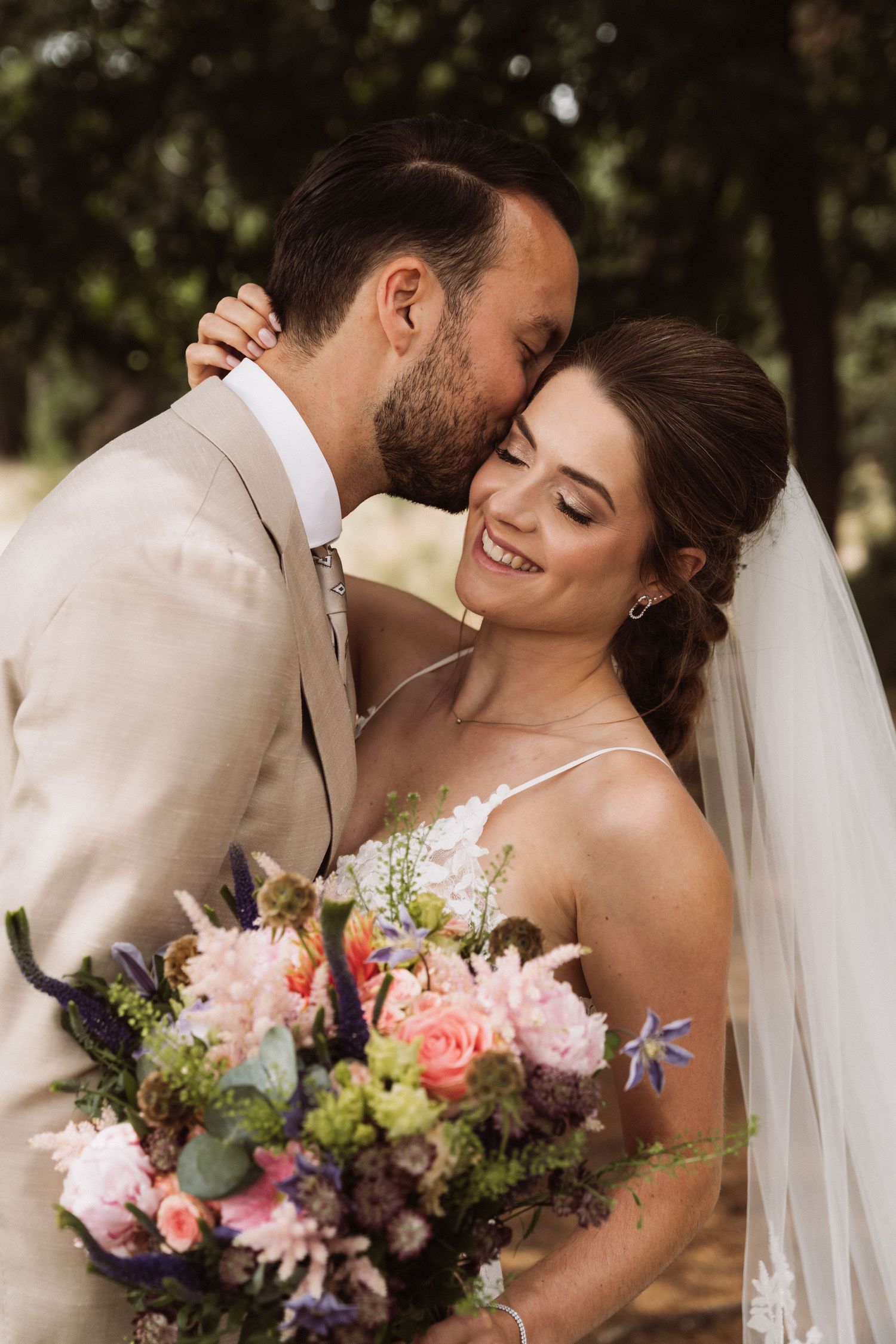 A romantic wedding moment with a beautiful bouquet of pink and purple flowers.