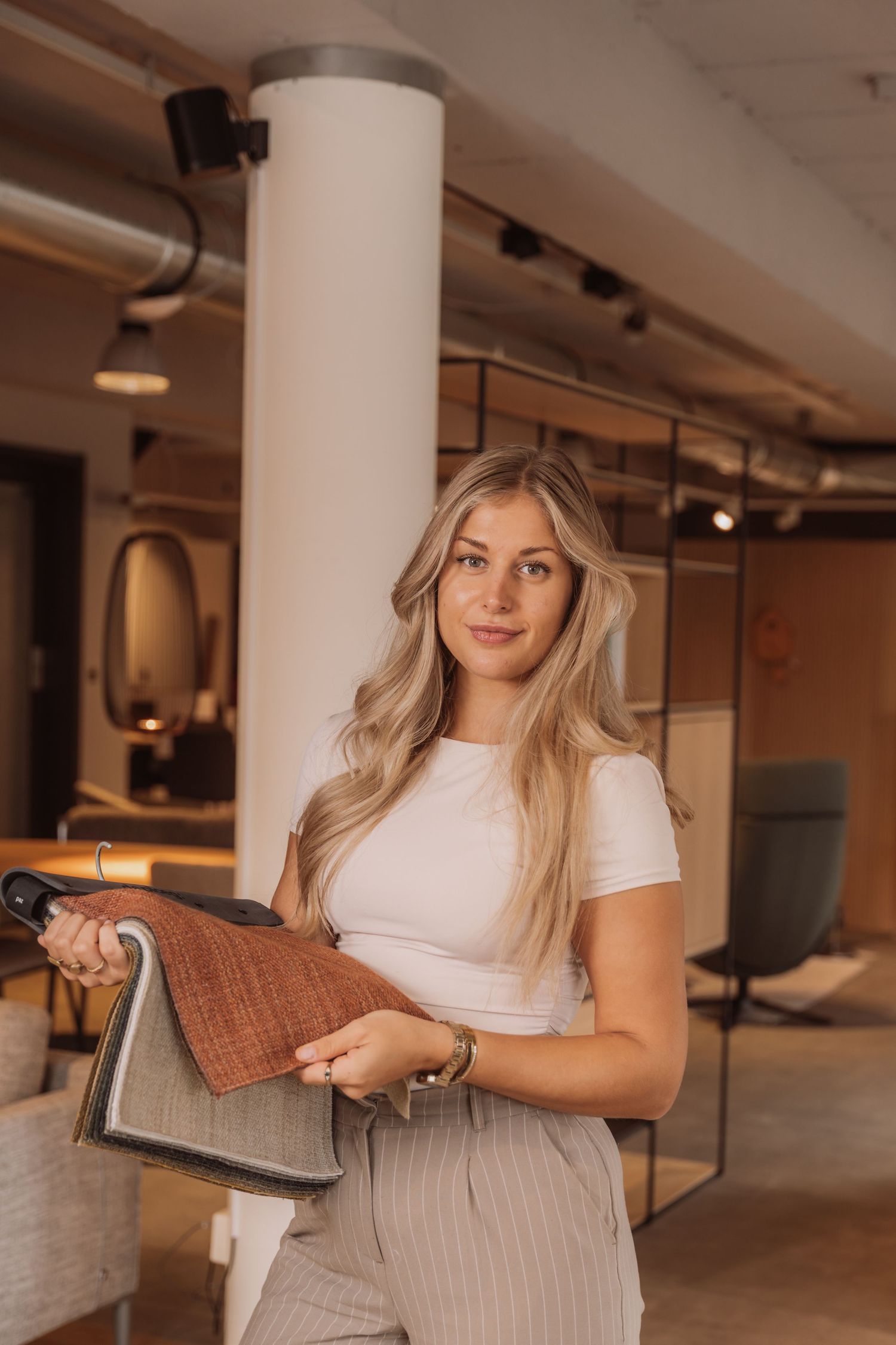 A professional holding fabric samples in a modern interior design showroom.