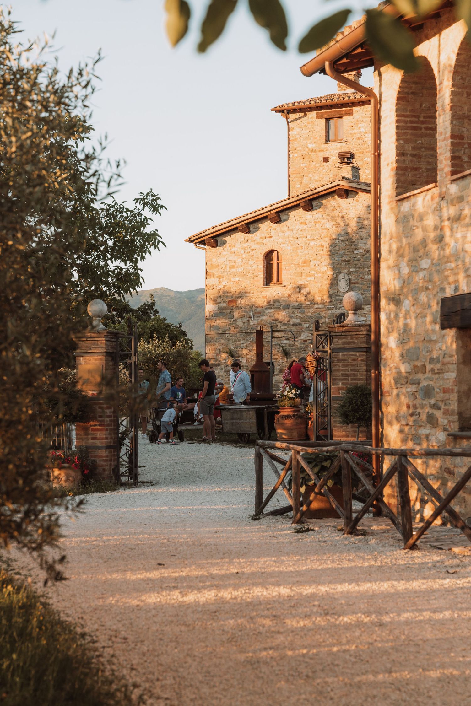 Rustic stone villa with wooden railings and terrace at sunset in Mediterranean countryside.