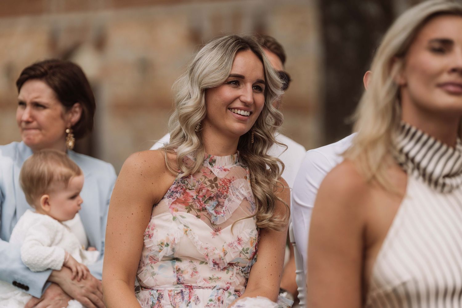 People gathered at an outdoor event with someone wearing a floral dress and others in casual attire.