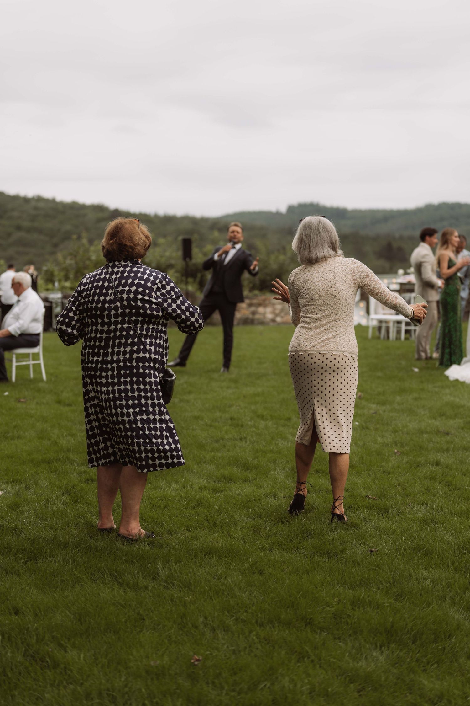 A sequence of photos showing people bending over to pick something up from a grassy field at an outdoor event.