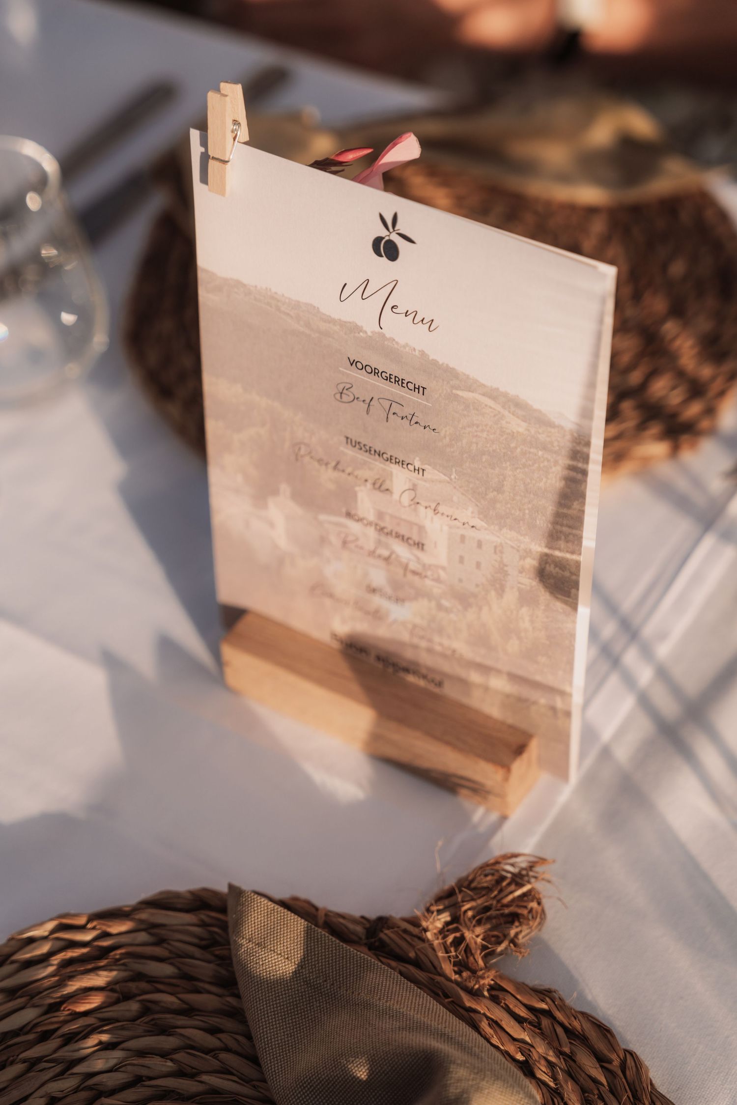 Wedding menu cards in soft beige tones cast delicate shadows on a textured surface in natural light.