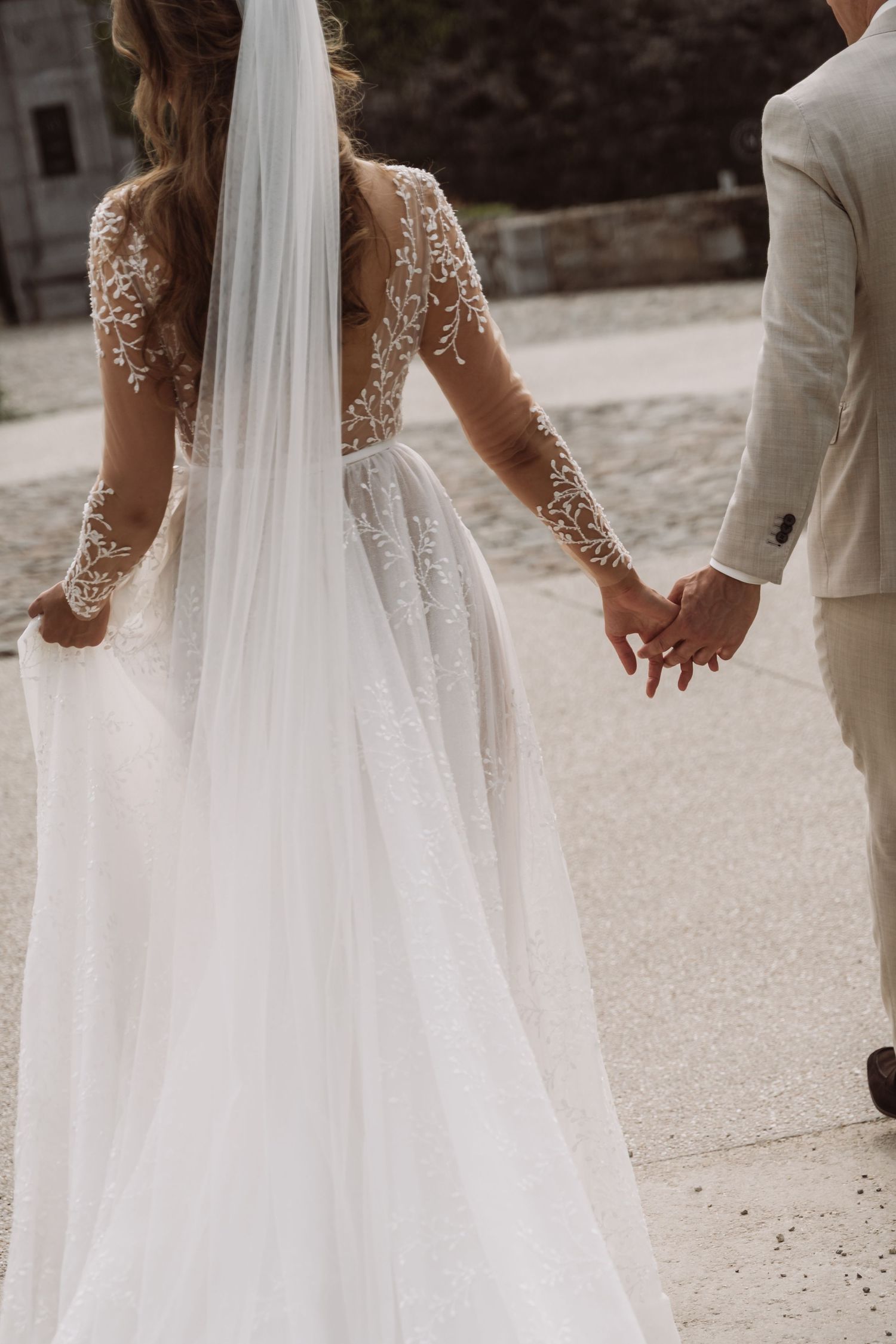 Back view of a flowing wedding dress with delicate lace details and long train.