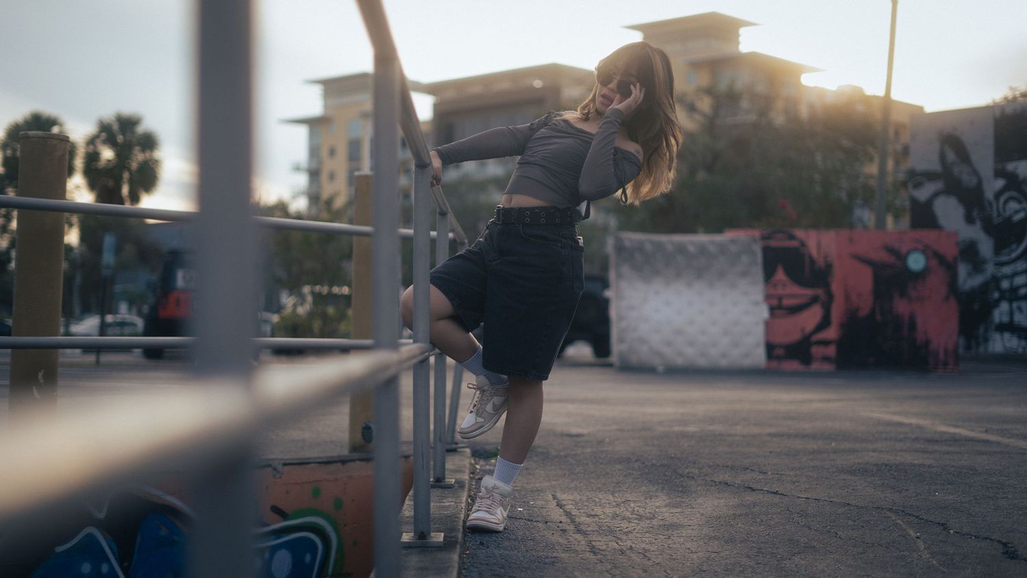 Portrait photo of Angela leaning off of a metal railing against the background of downtown St. Petersburg, FL.