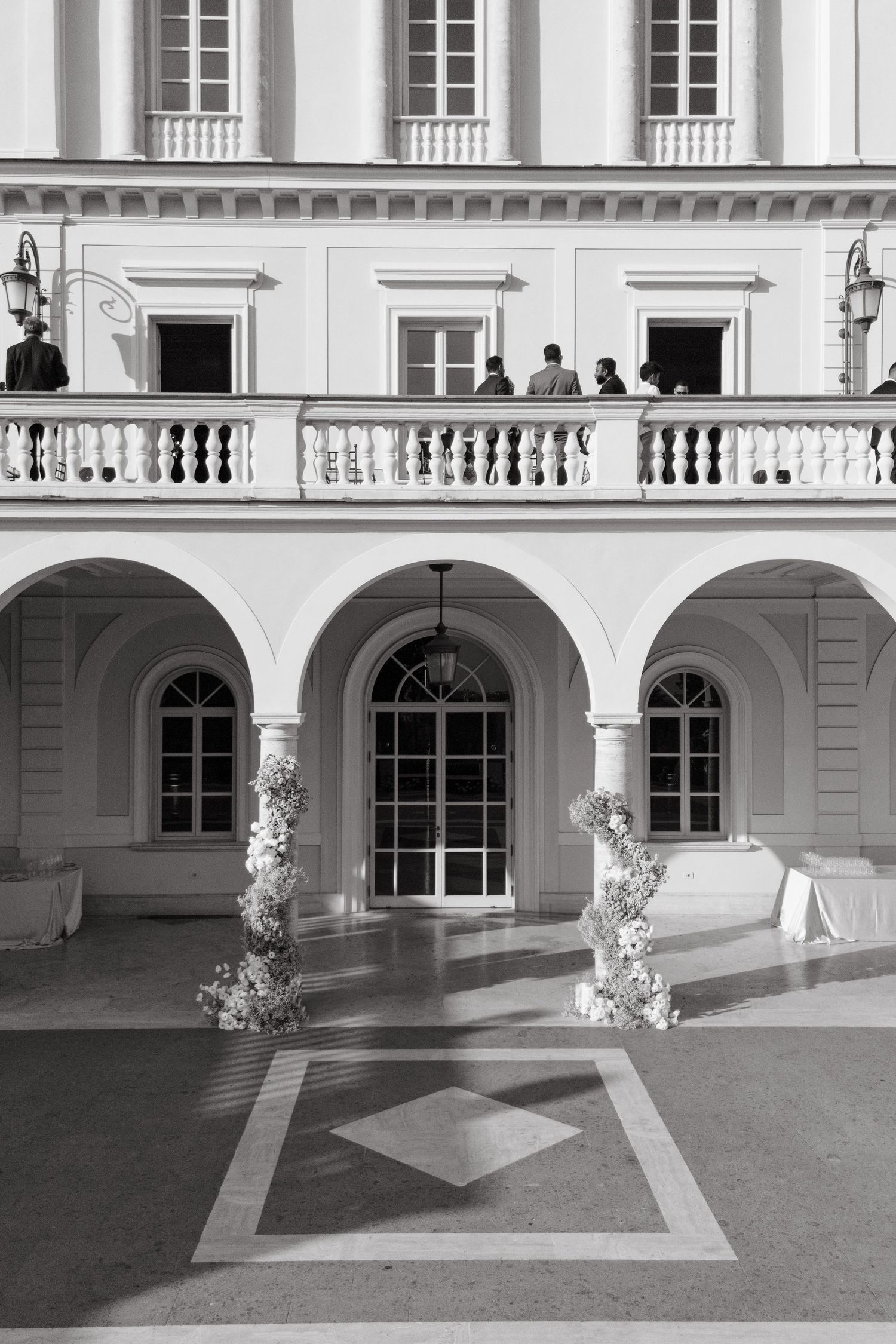 Classical white architecture with arched windows and balustrades in black and white photography.