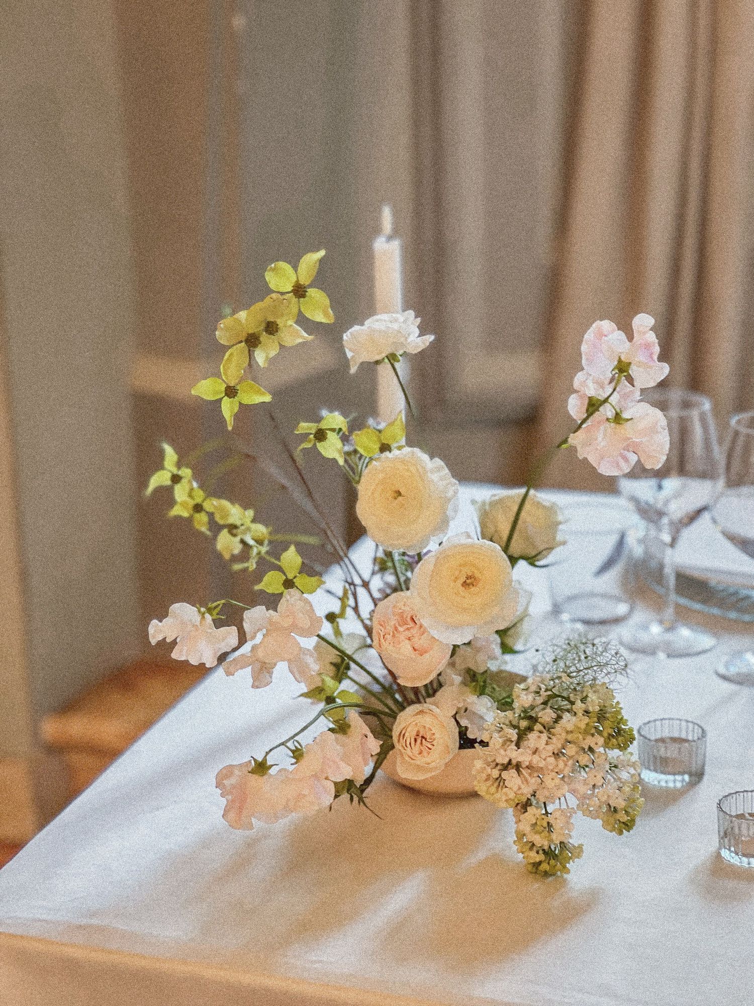 Delicate floral composition in pastel tones, floral centerpiece arrangement on white tablecloth. Destination Wedding Rome Italy