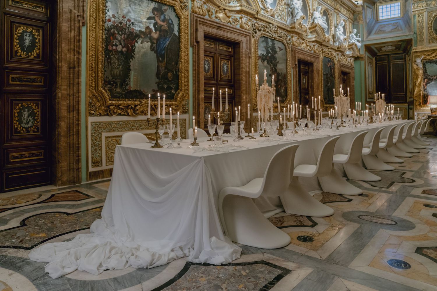 Luxurious wedding reception table setting in ornate Italian palace with crystal candelabras.