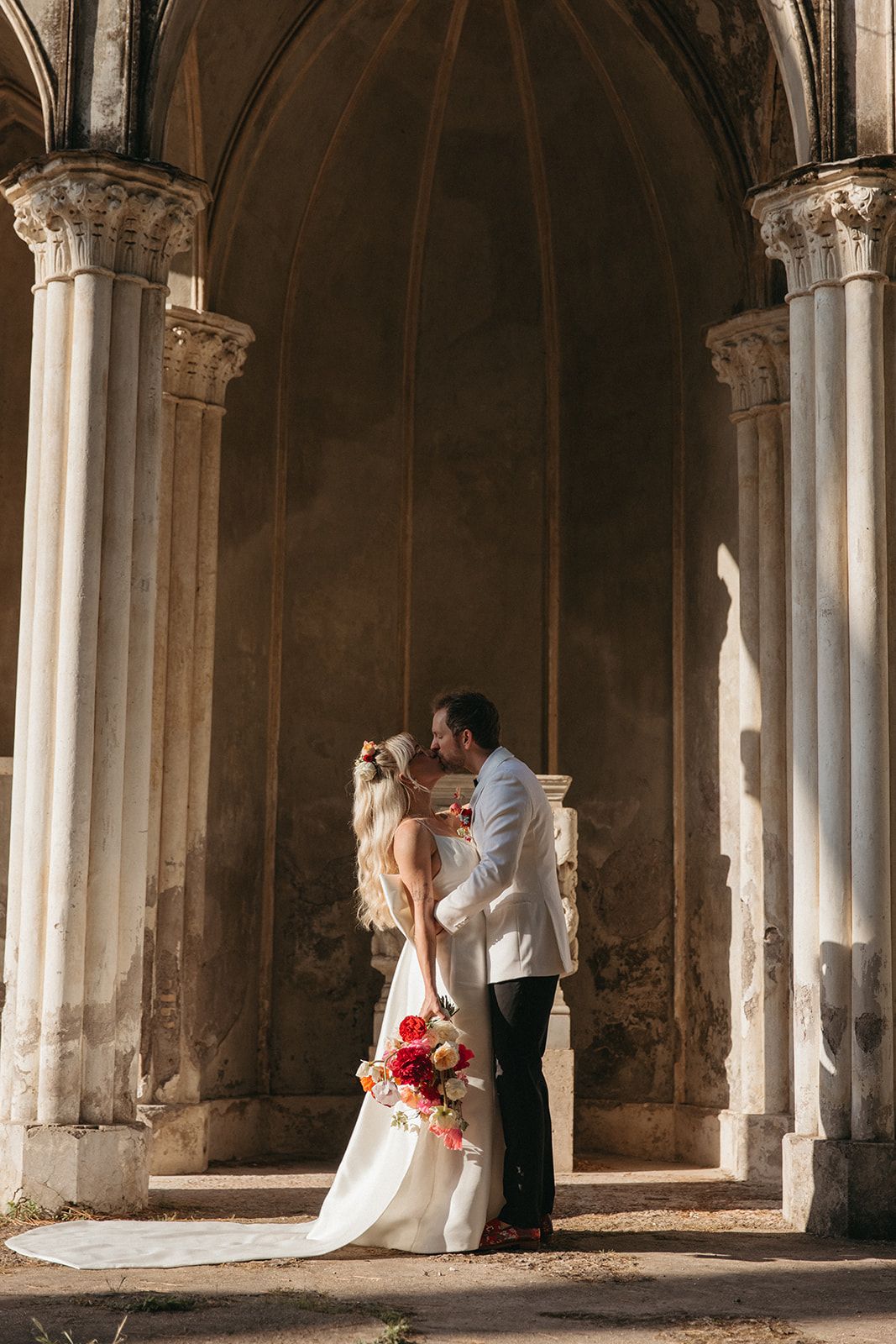 Romantic wedding photoshoot in historic stone archways with dramatic lighting, destination wedding