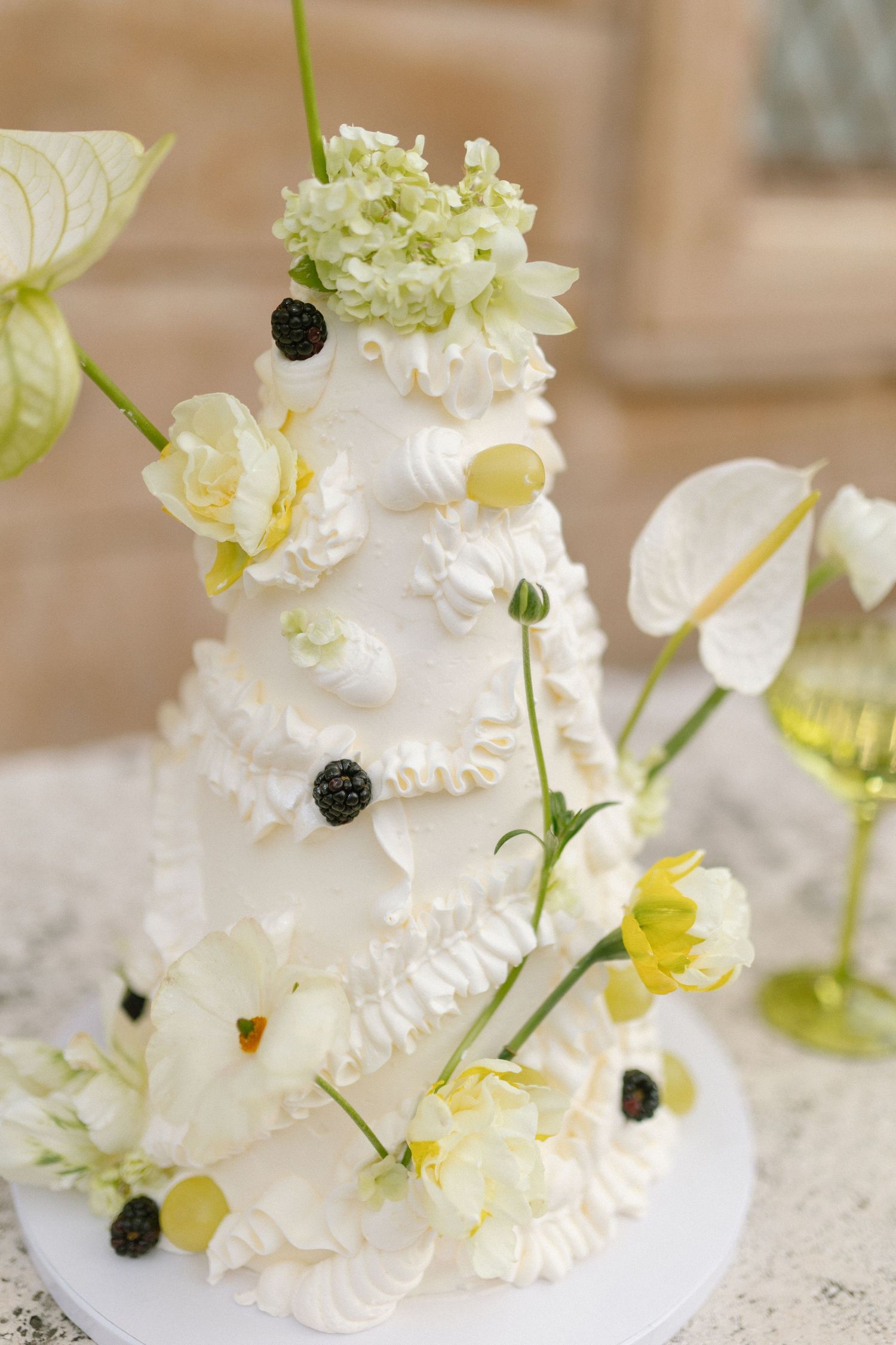 Elegant white wedding cake adorned with fresh flowers and delicate frosting details.
