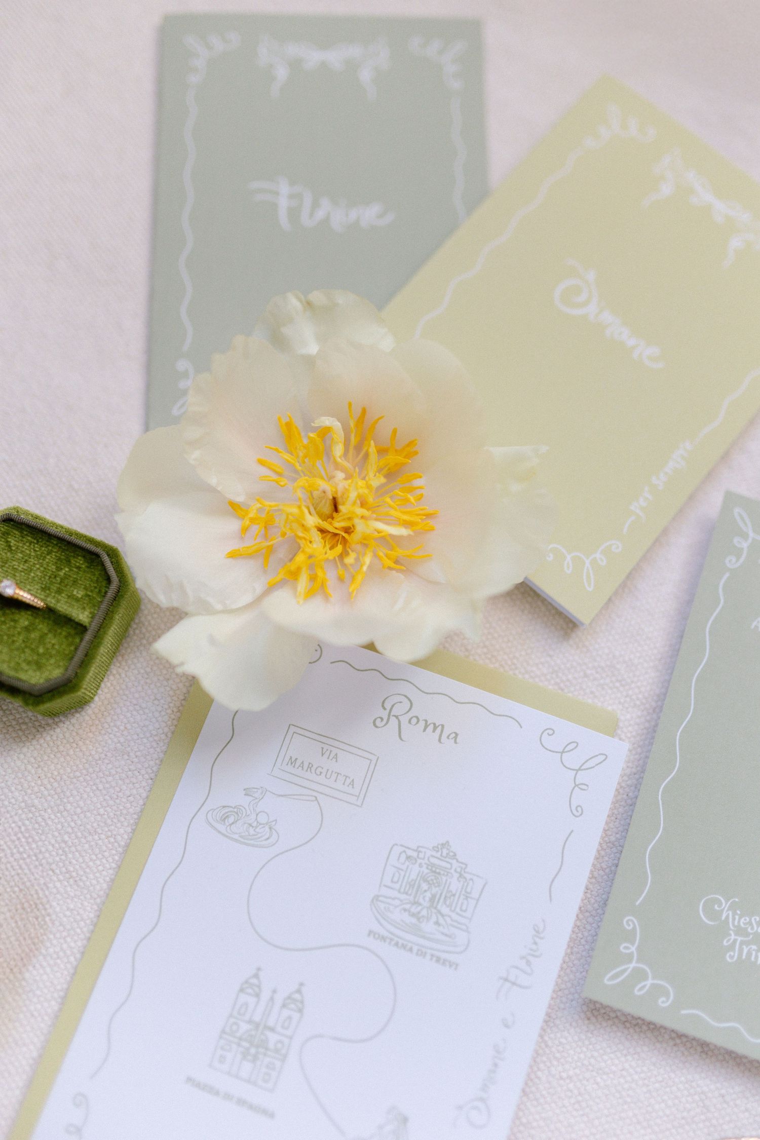 Wedding stationery in soft sage and yellow tones with floral accents.