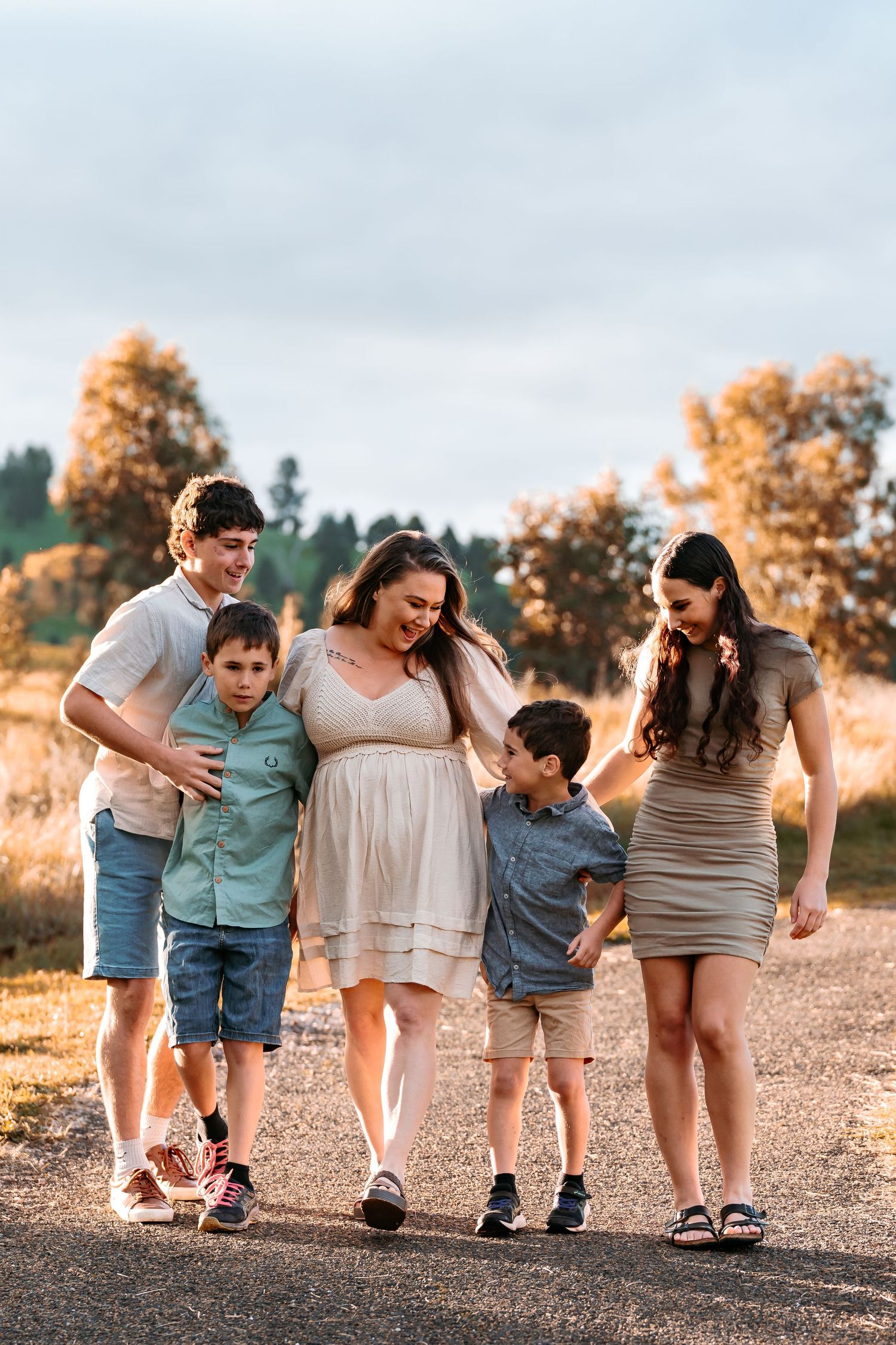 an image of a family walking, they are all looking at one another and laughing. the image is not posed or staged, natural connection