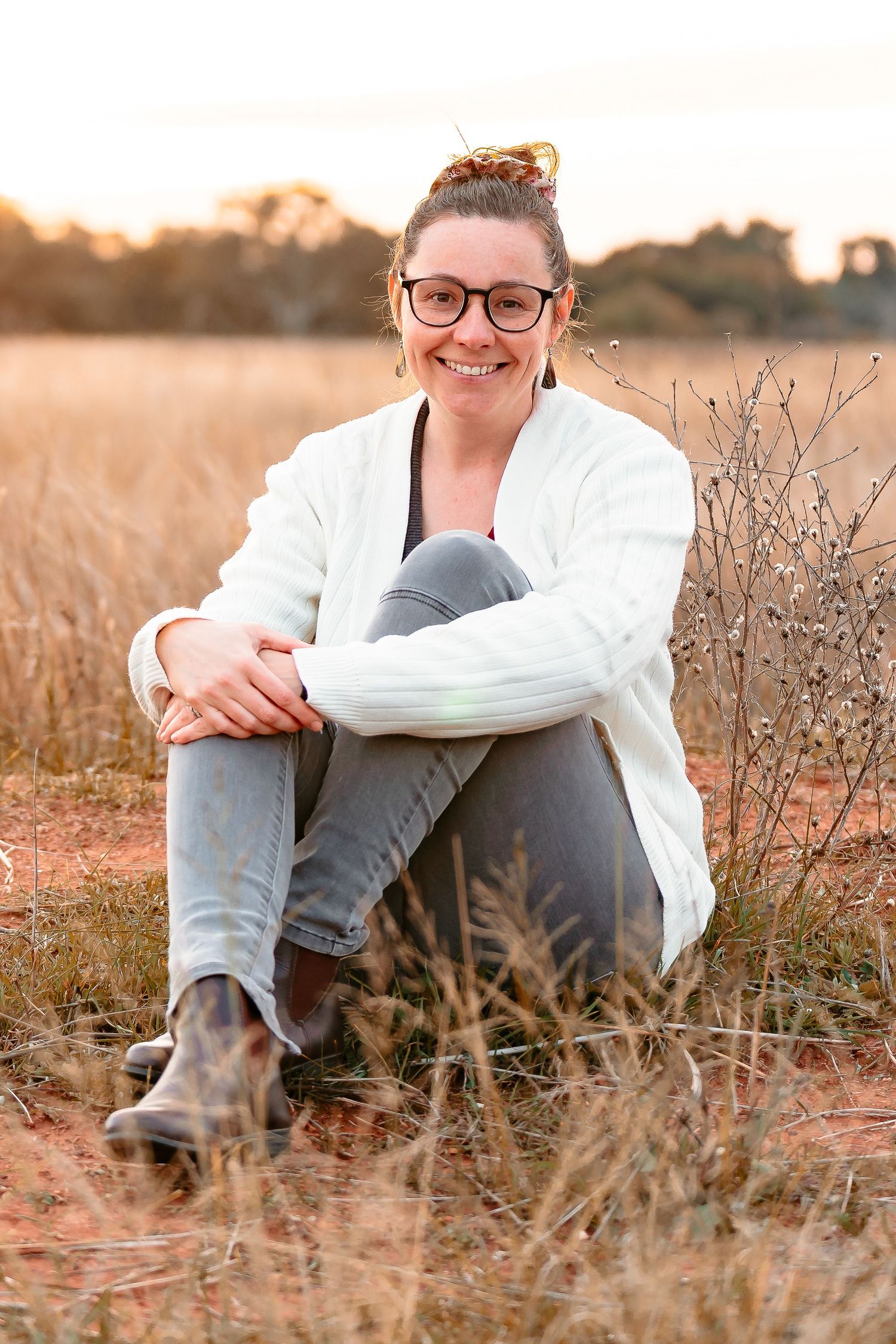 Photographer sitting and smiling at the camera. Photographer appears relaxed, approachable and friendly