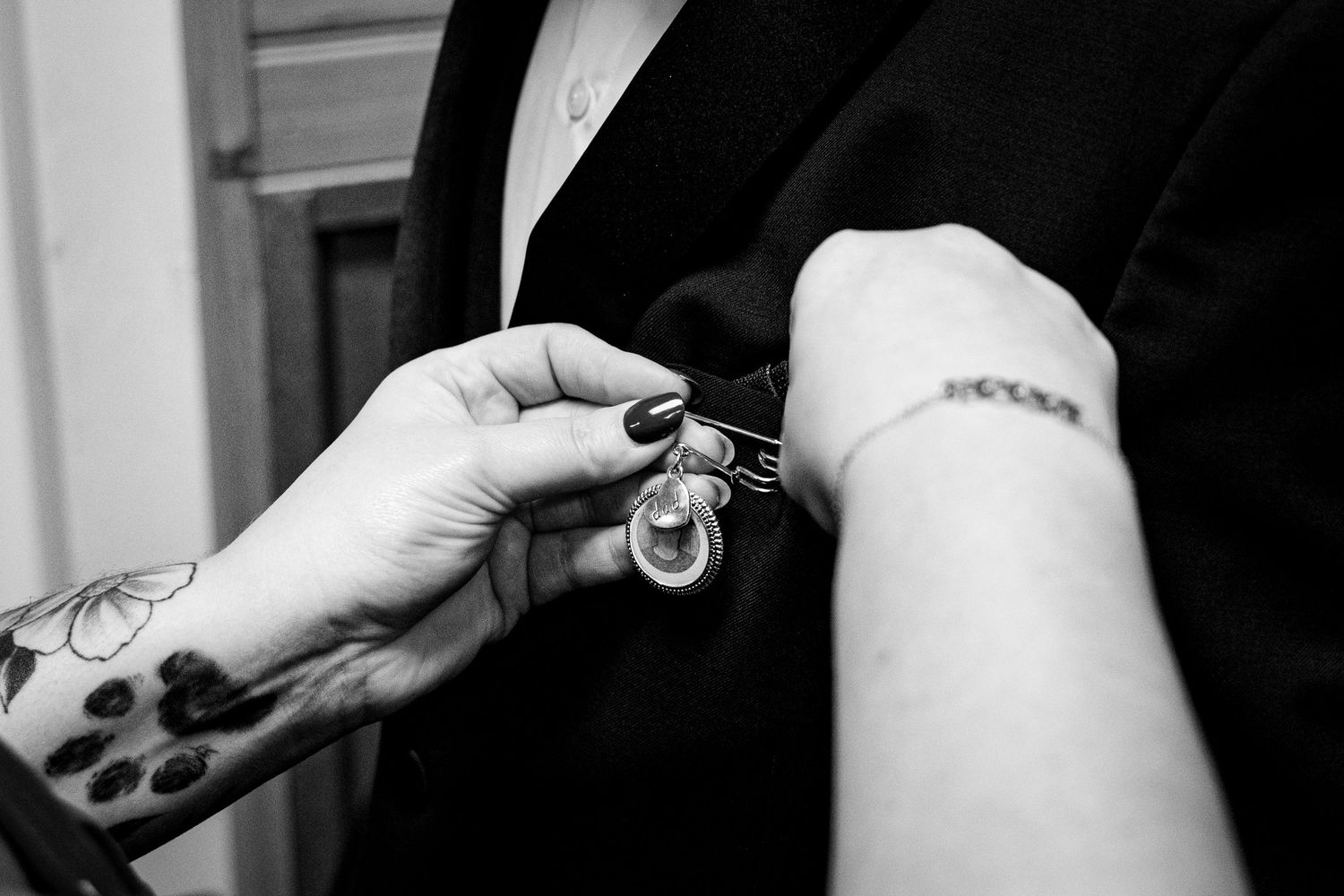 Black and white detail shots of wedding dress preparations.
