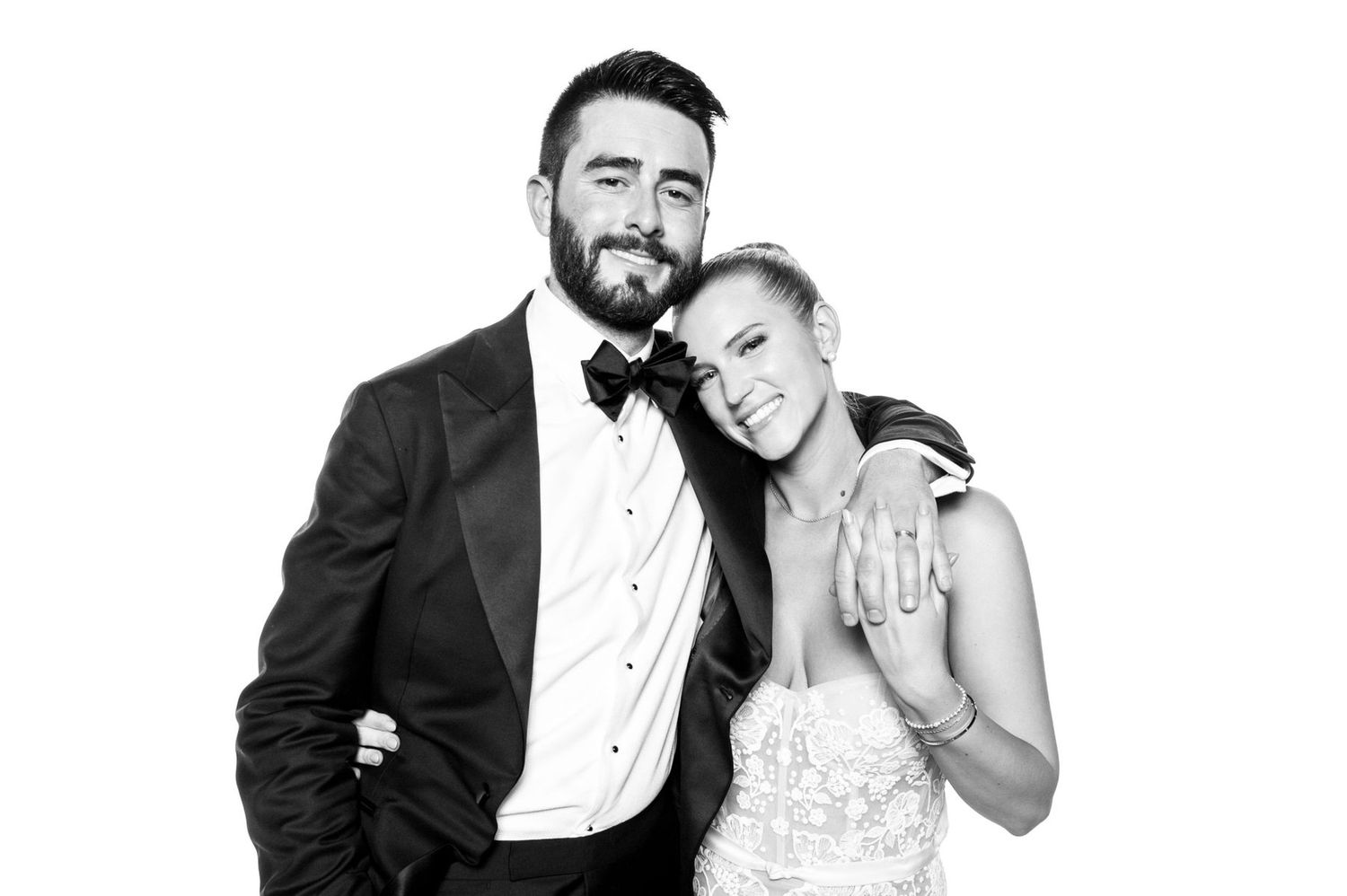 Black and white portrait of a couple in formal wedding attire embracing and smiling together.