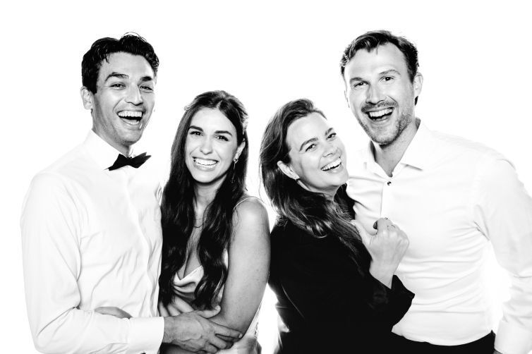 Joyful black and white portrait series showing couple laughing together in casual white outfits.