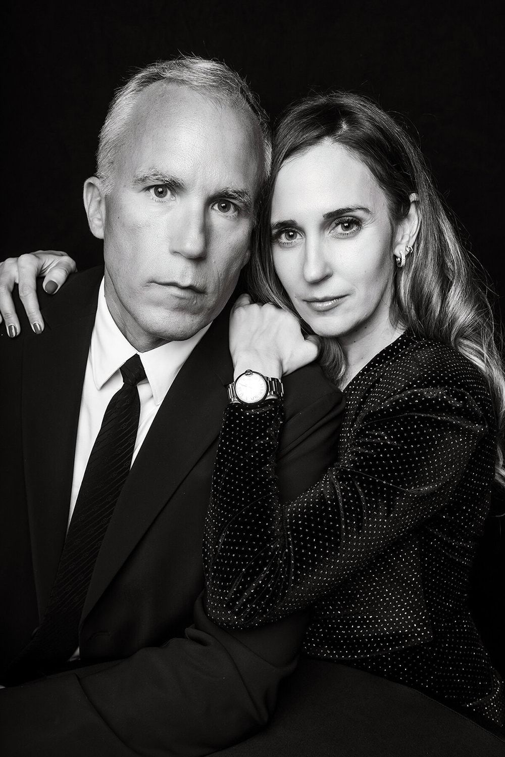 Sophisticated couple poses in formal black attire for dramatic monochrome portrait series.