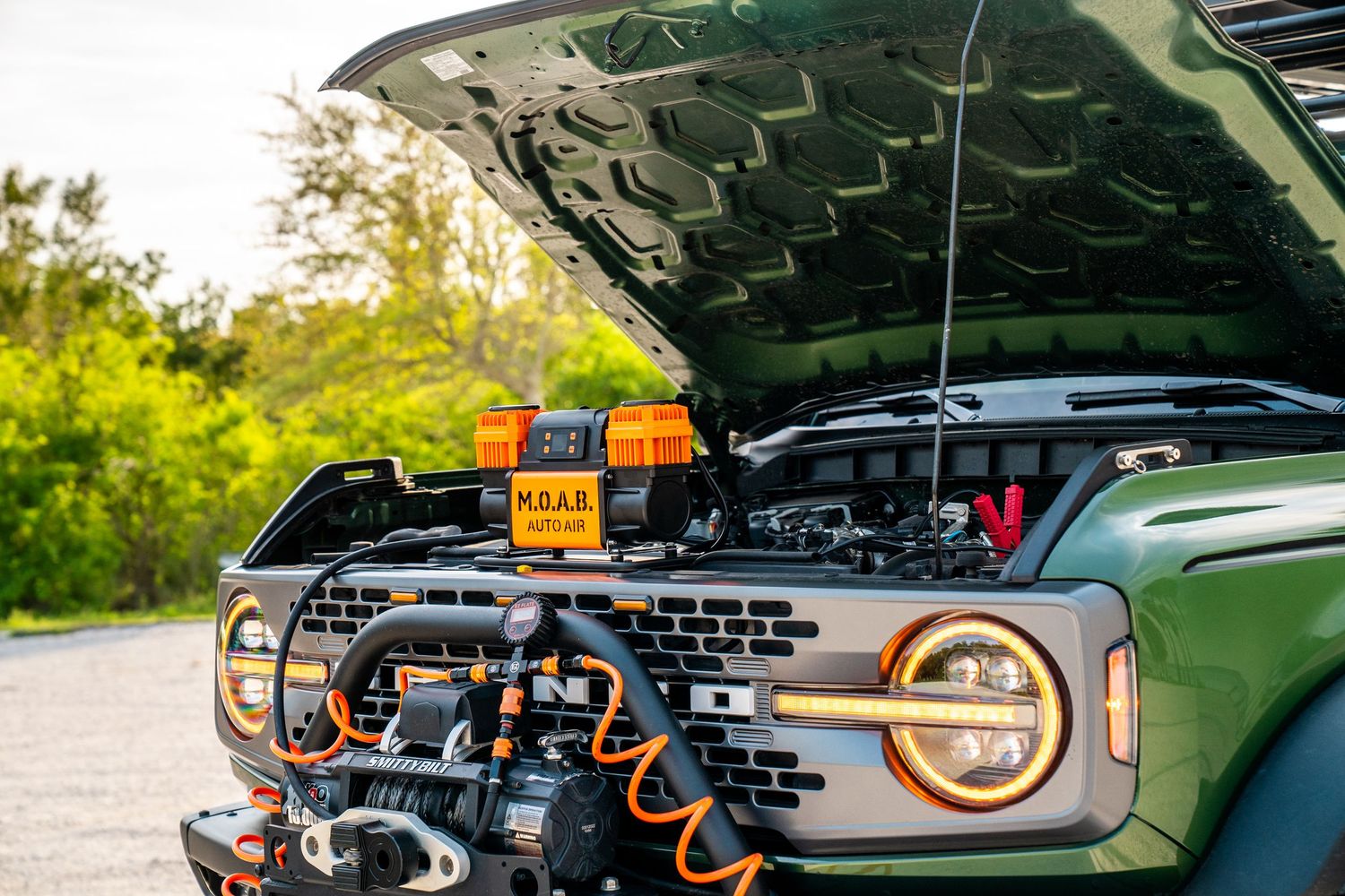 Vehicle roof rack system with multiple orange mounting brackets and accessories.