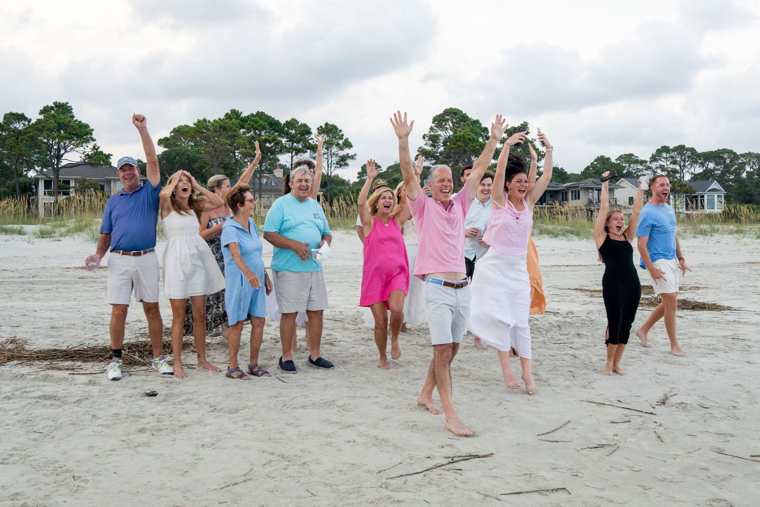 A group of people jumping and celebrating together on a sunny beach.