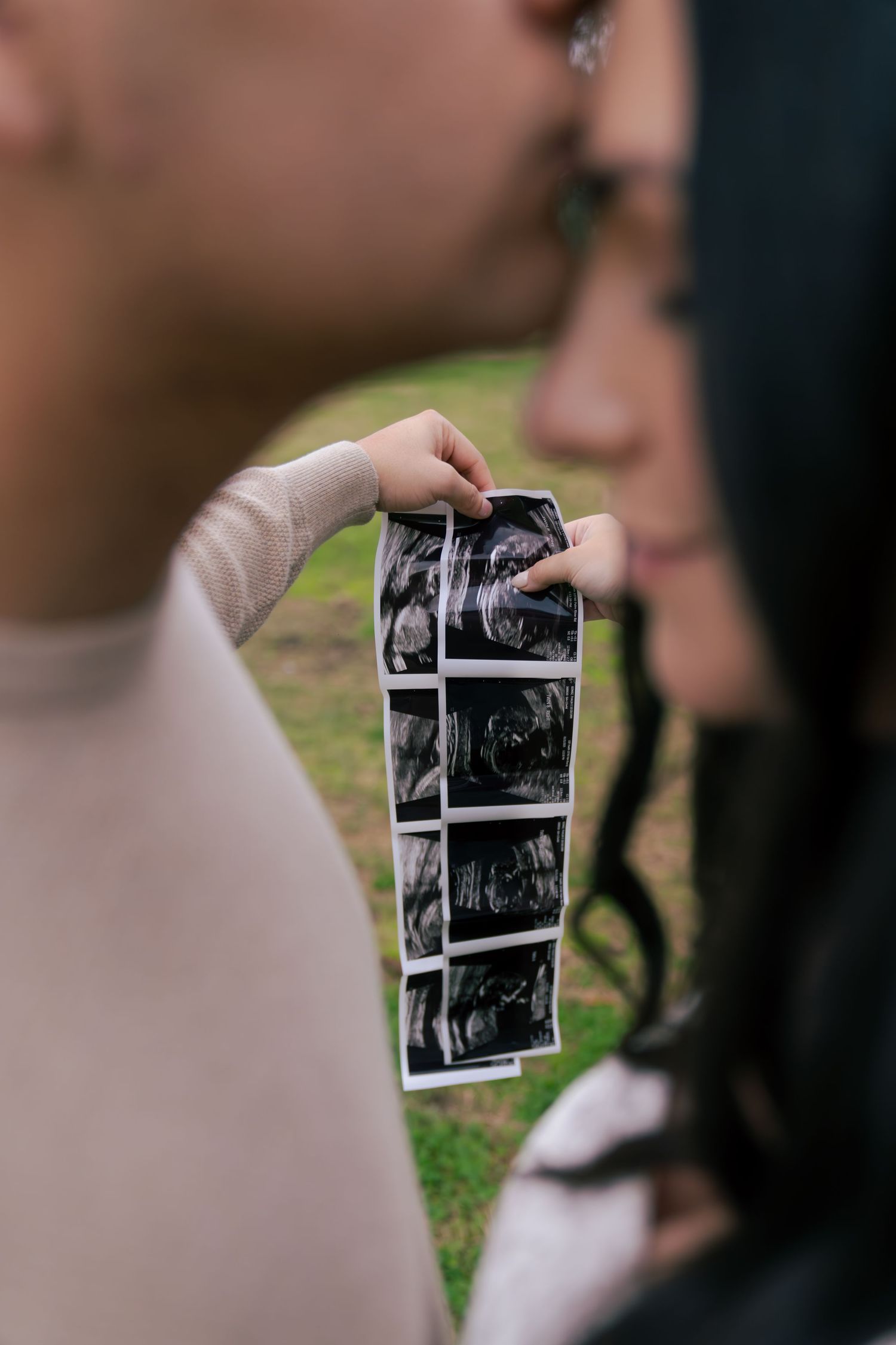 A sequence of black and white polaroid photographs being held up and displayed in an outdoor setting.