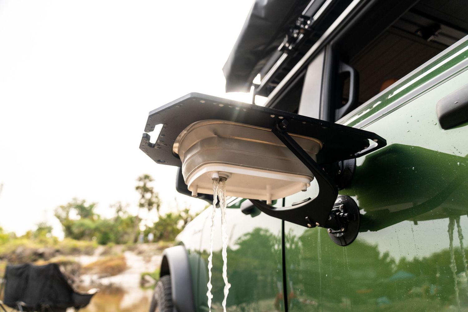 View through car windshield showing rearview mirror and roof mounted accessories.