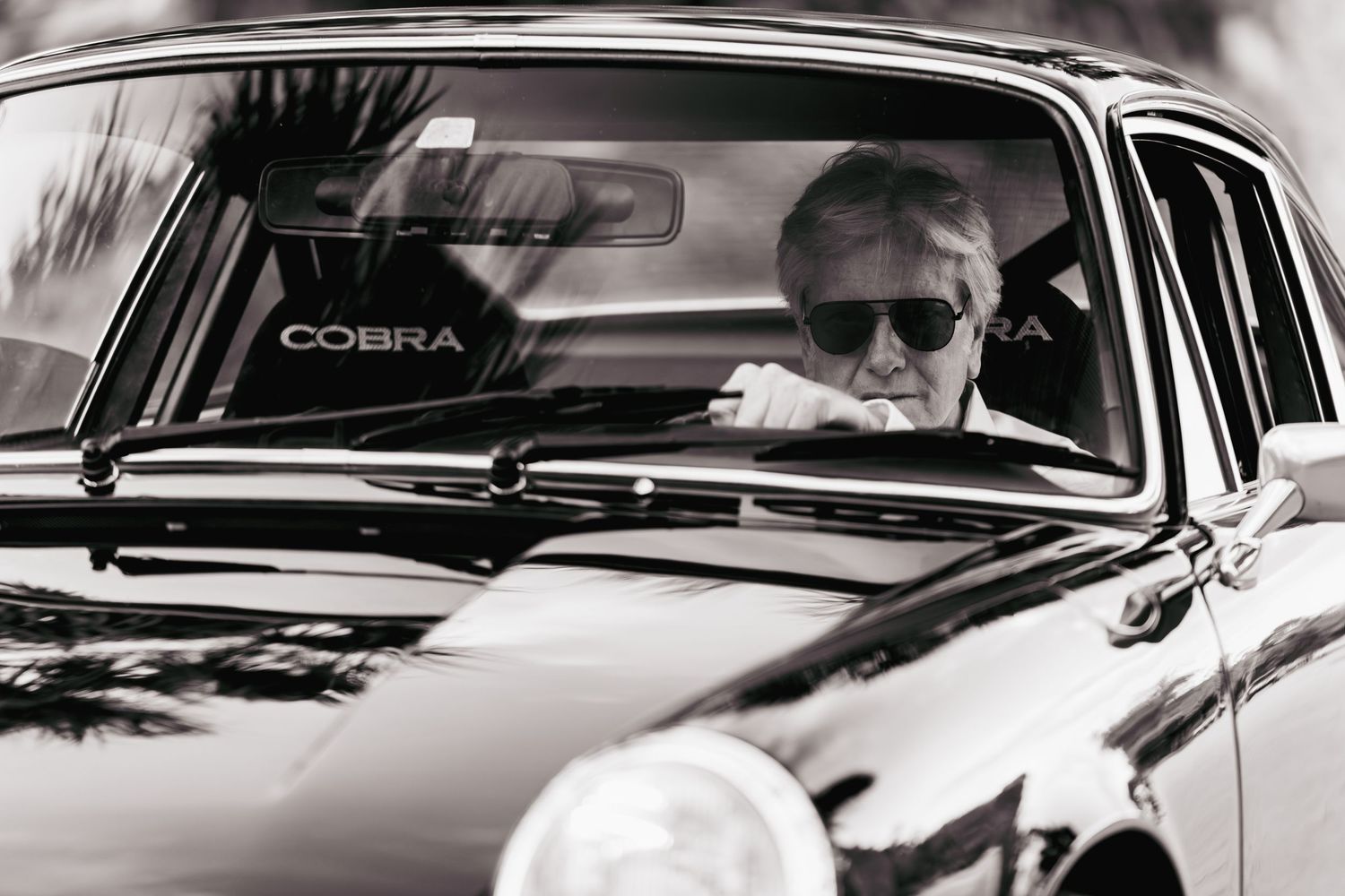 Black and white photo series showing a classic Ford Mustang Cobra car from different angles and perspectives.