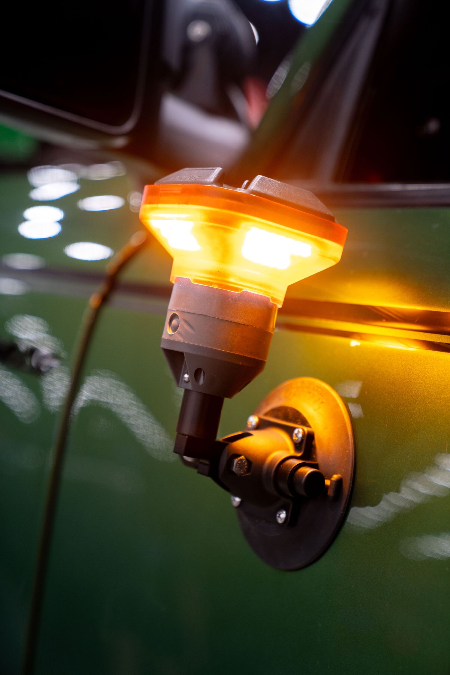Close-up of amber warning lights mounted on a vehicle showing sequential illumination pattern.