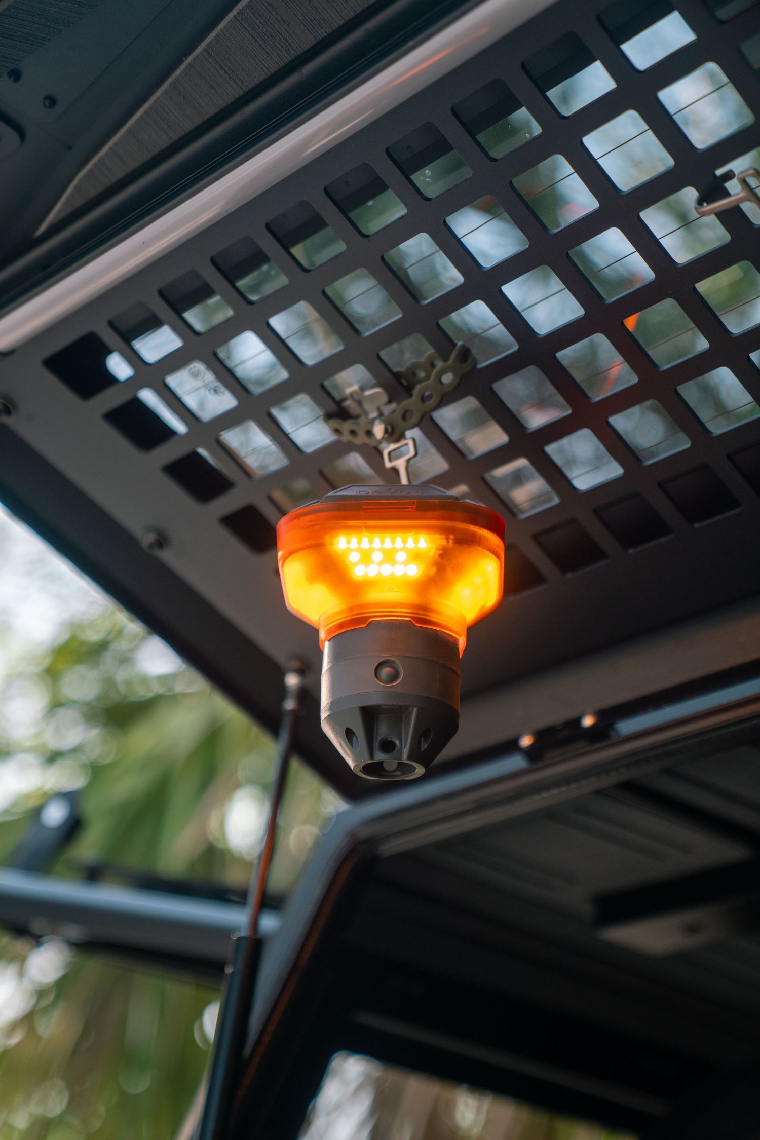 Orange LED safety lights mounted on black vehicle roof rack grid system.