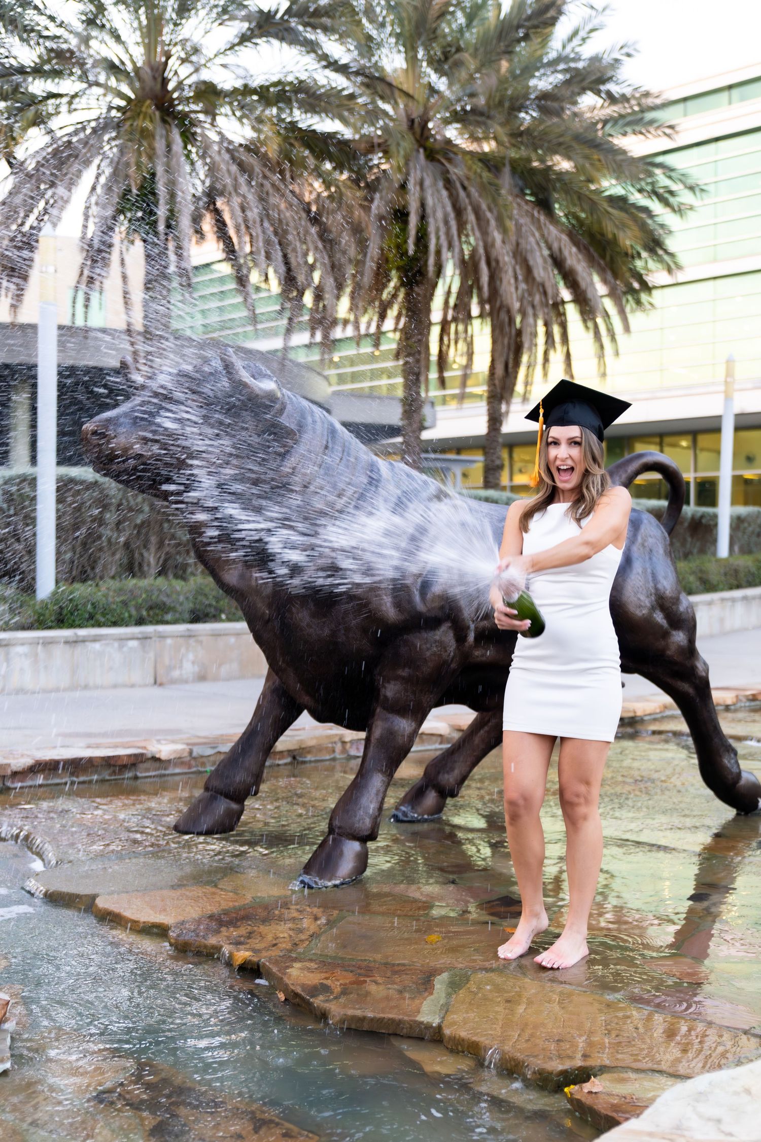 A sequence of playful poses with a bronze panther statue outside a building with palm trees in the background.