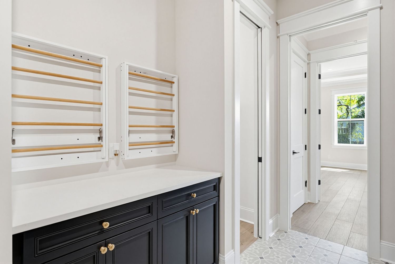 Modern white hallway with wood slat wall accents and black cabinets features clean lines and minimalist design.
