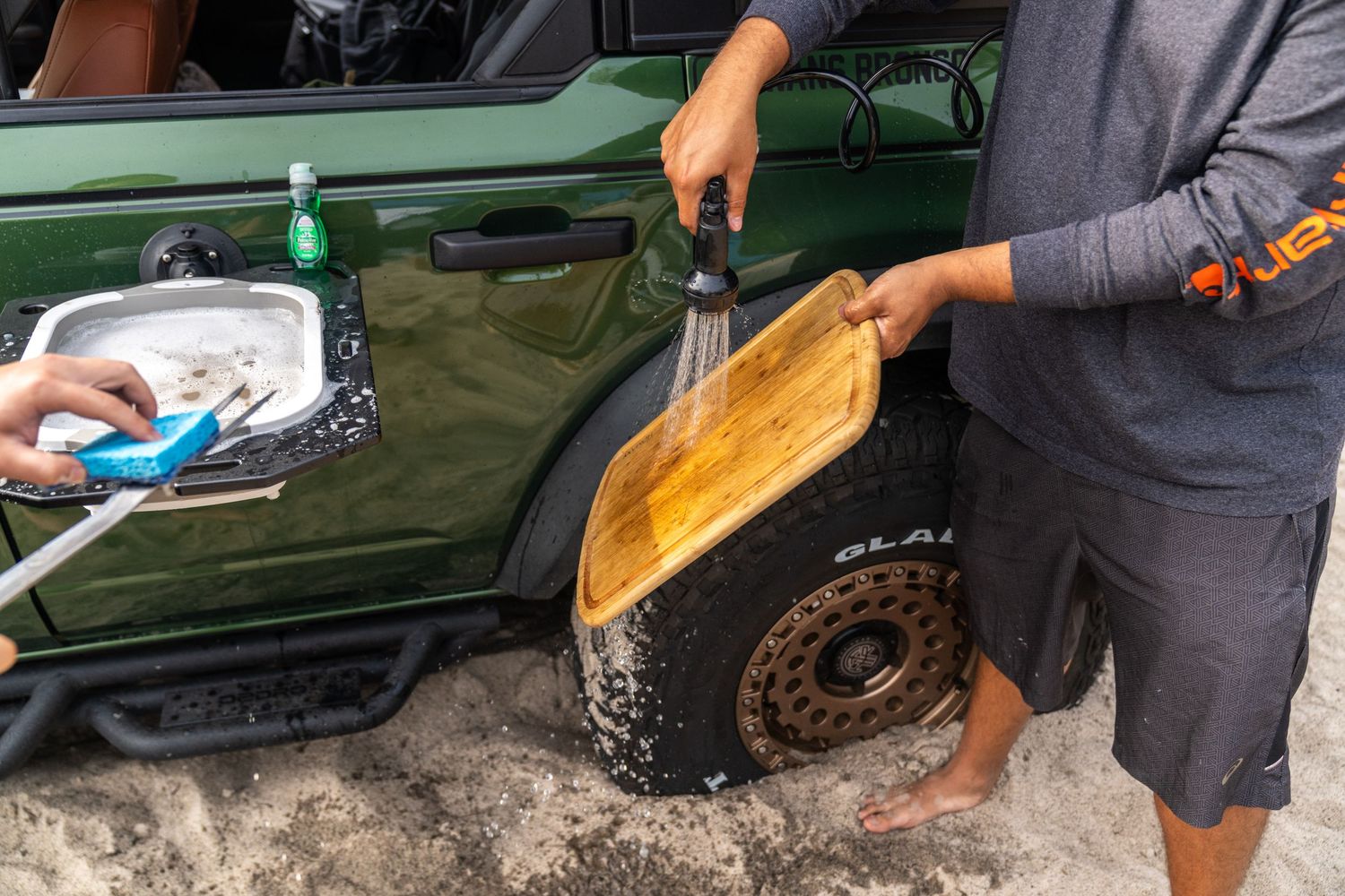Installing or maintaining equipment on green off-road vehicle.