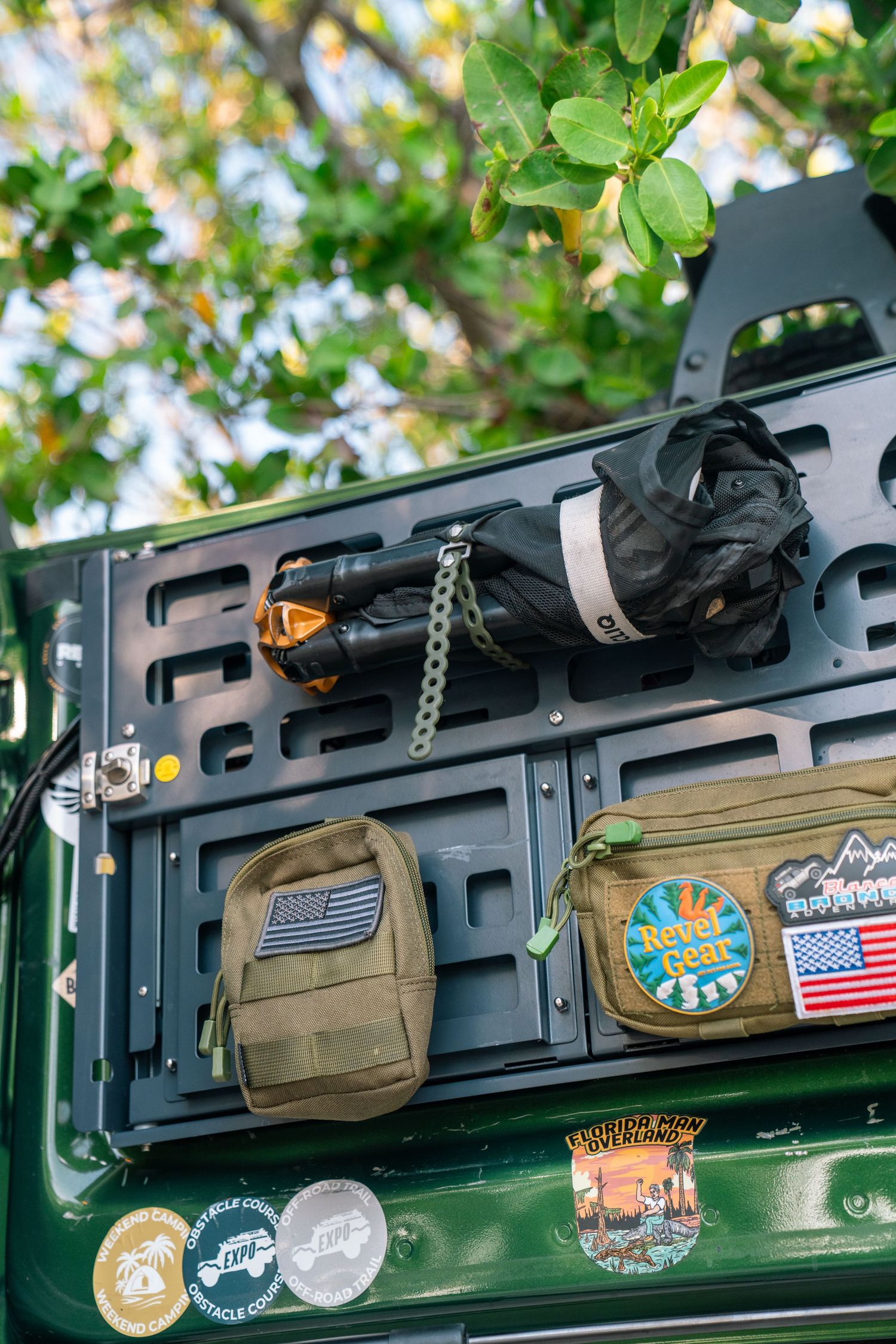Molle panel mounted on vehicle with various patches and tactical accessories displayed.