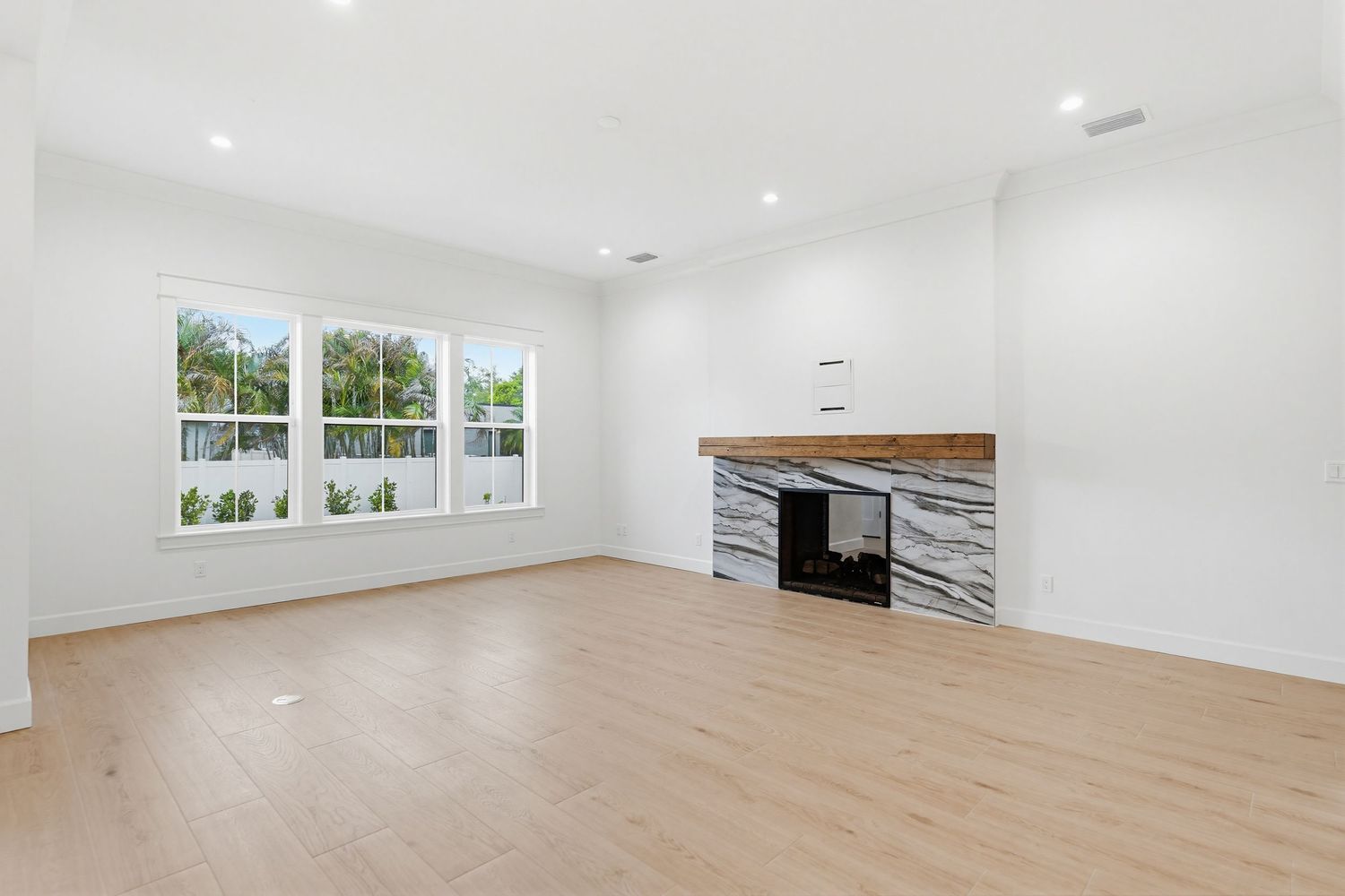 Bright, modern yoga studio with light hardwood floors, white walls, and large windows letting in natural light.