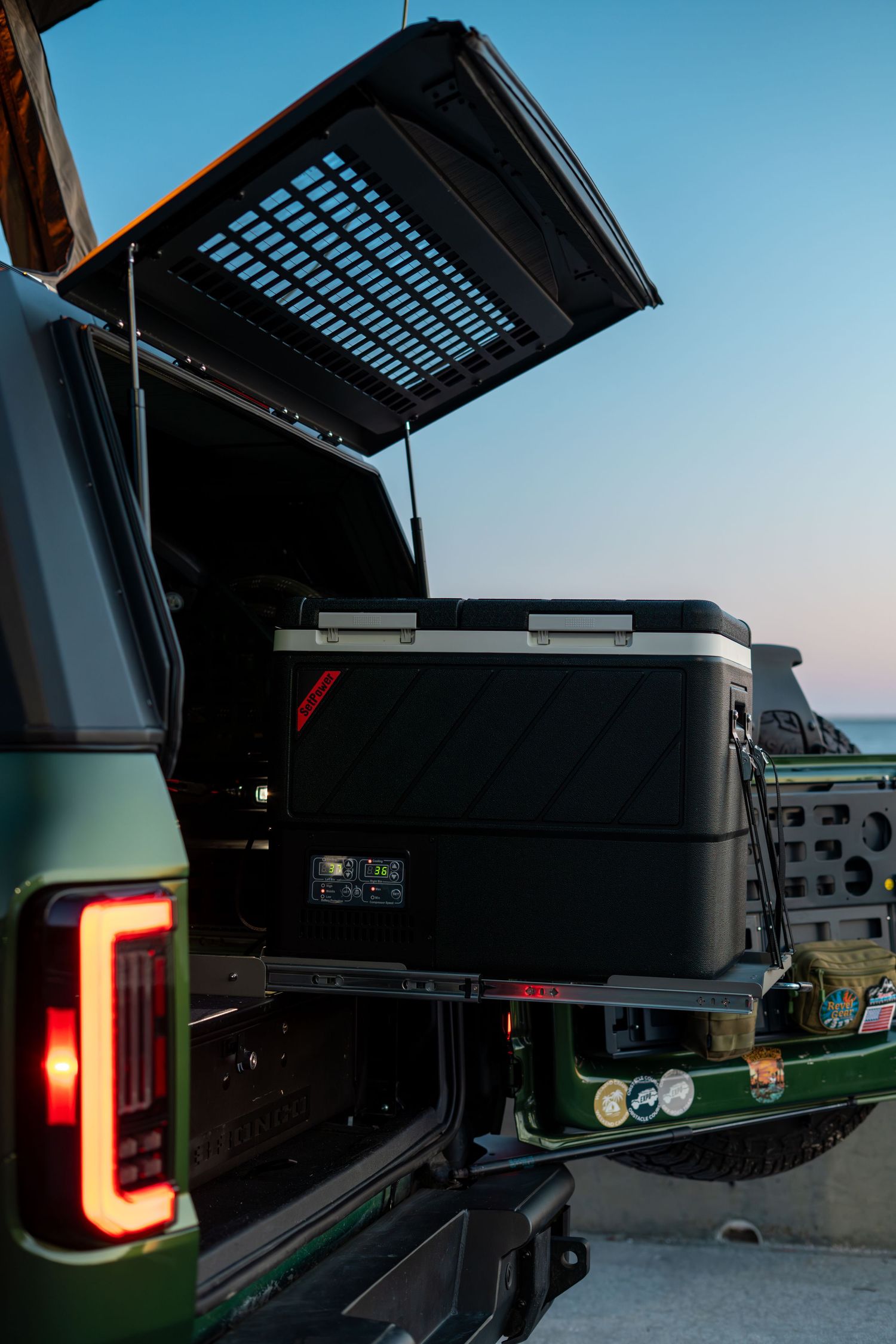 Custom truck tail lights and rear accessories photographed at dusk against blue sky.