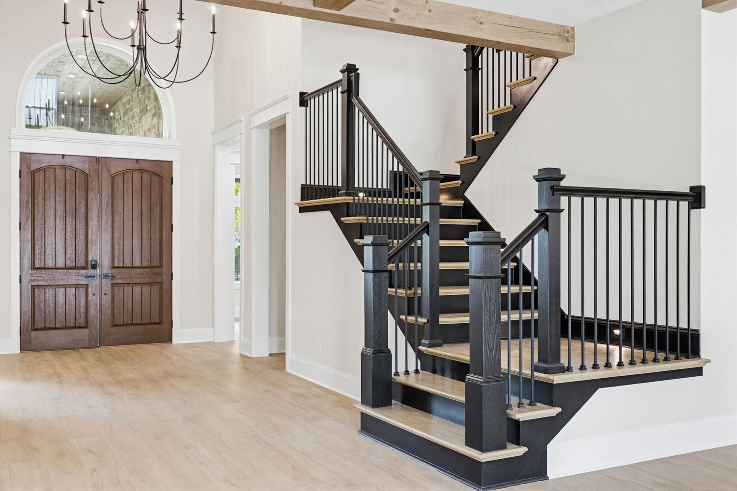 Modern staircase with dark wood handrails and white walls showcases elegant craftsman-style design details.