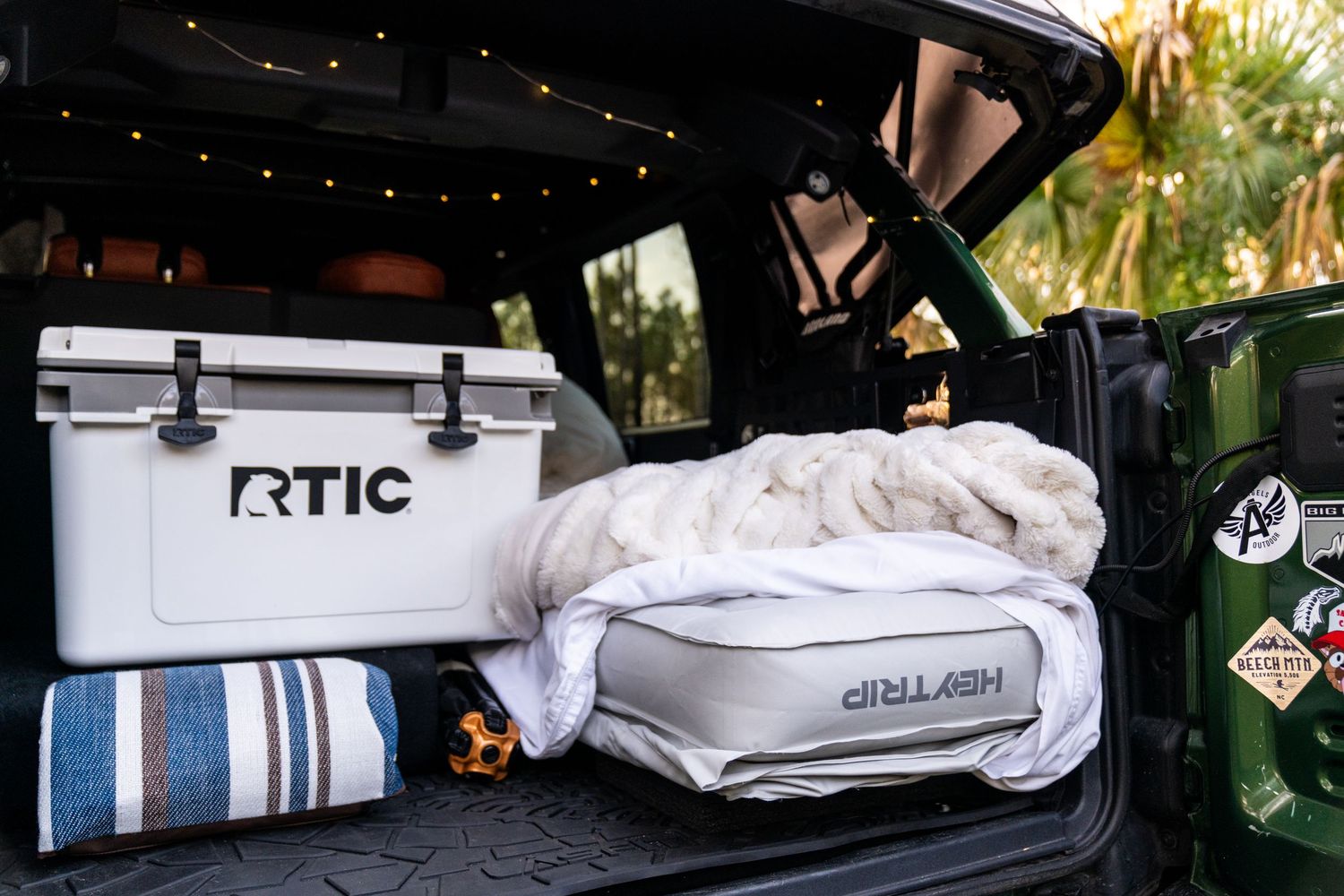 Camping gear and equipment packed neatly in the back of a vehicle.