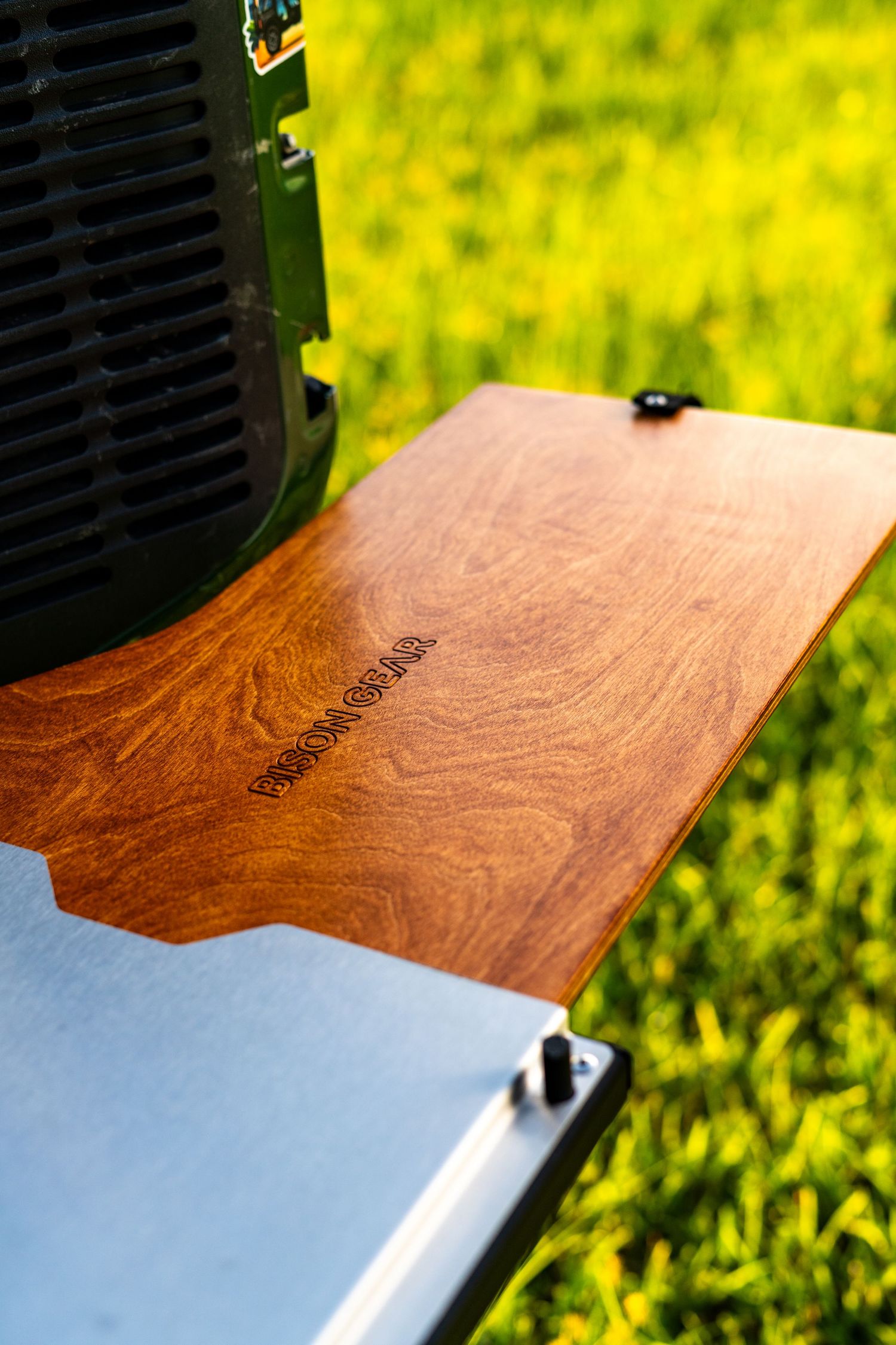 Close-up of wooden surface detail with natural grain patterns against blurred yellow-green background.