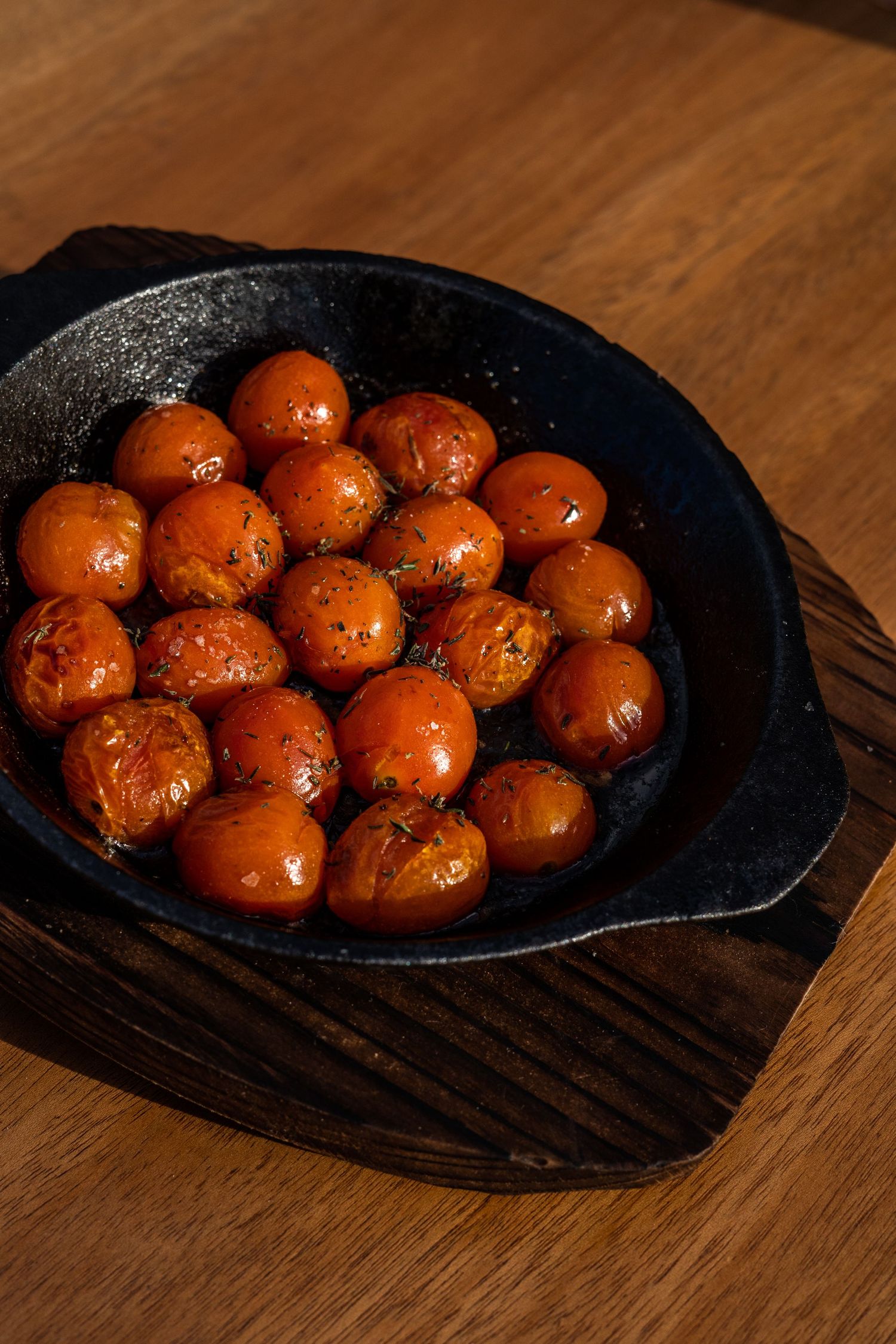 Glazed meatballs arranged in a rustic cast iron pan on a wooden surface, shown in progressive serving angles.